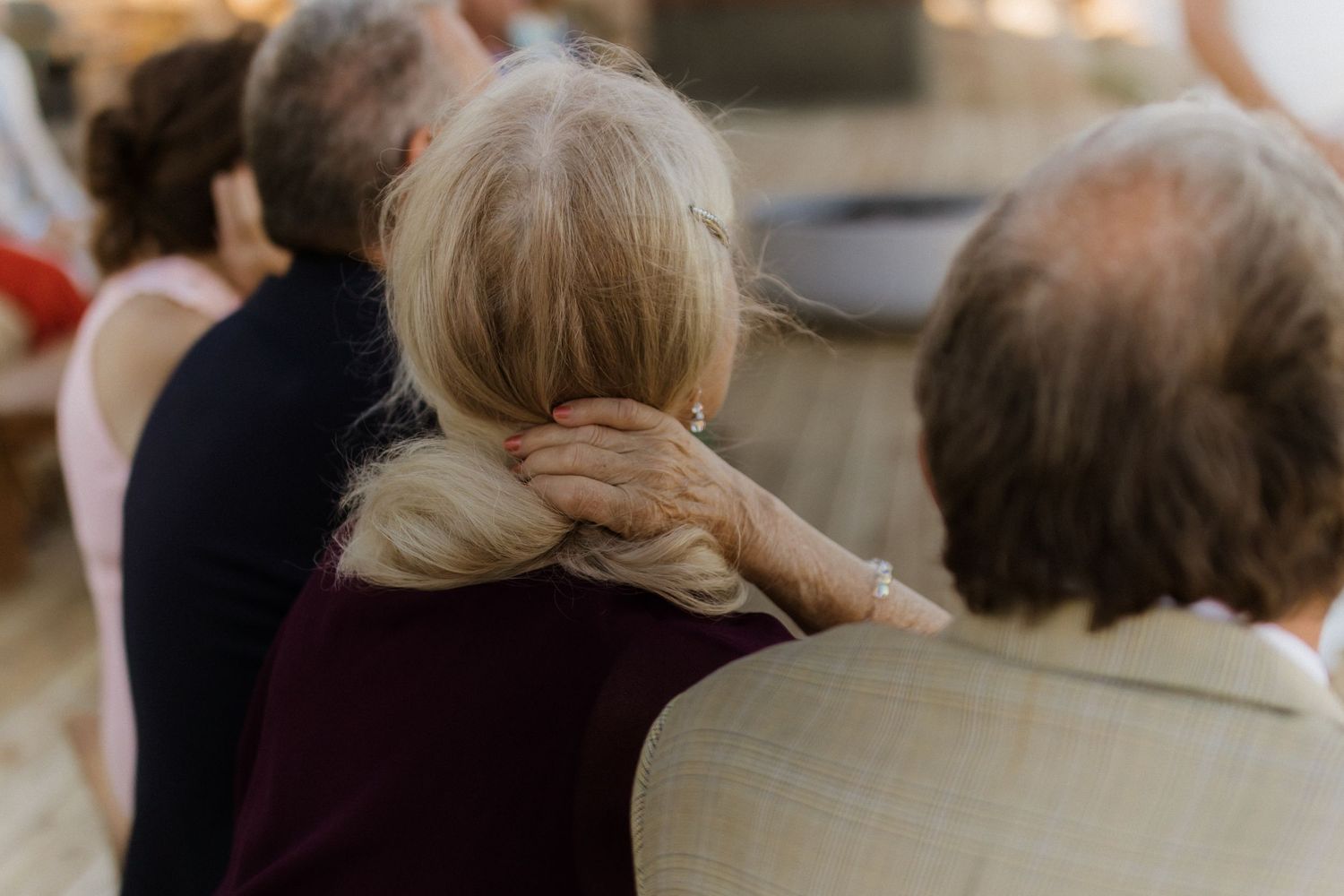 Elderly people sitting together at a gathering, with focus on their silver hair and casual attire.
