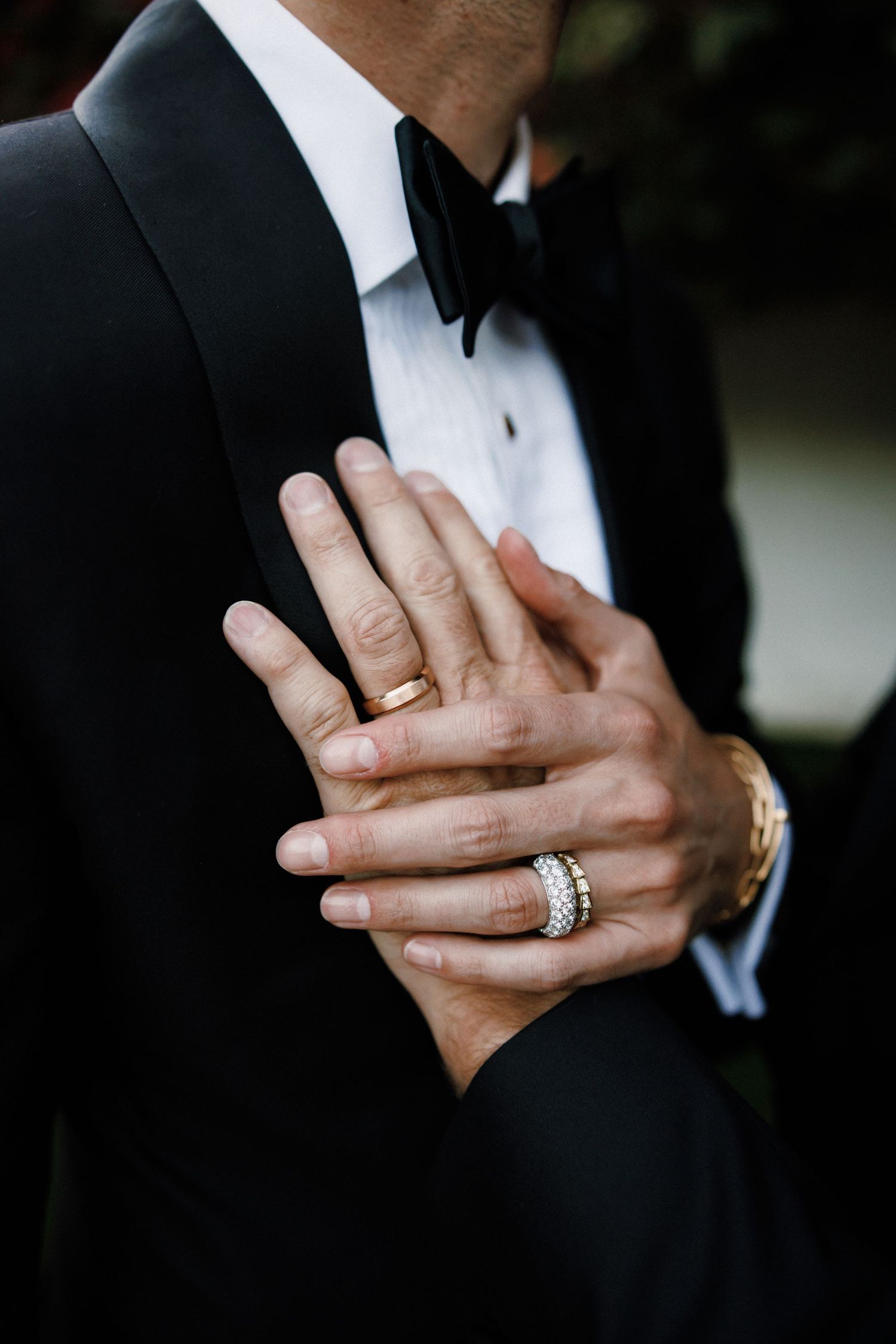 Close-up sequence of hands showing wedding rings and engagement ring against black formal attire in romantic detail shots.