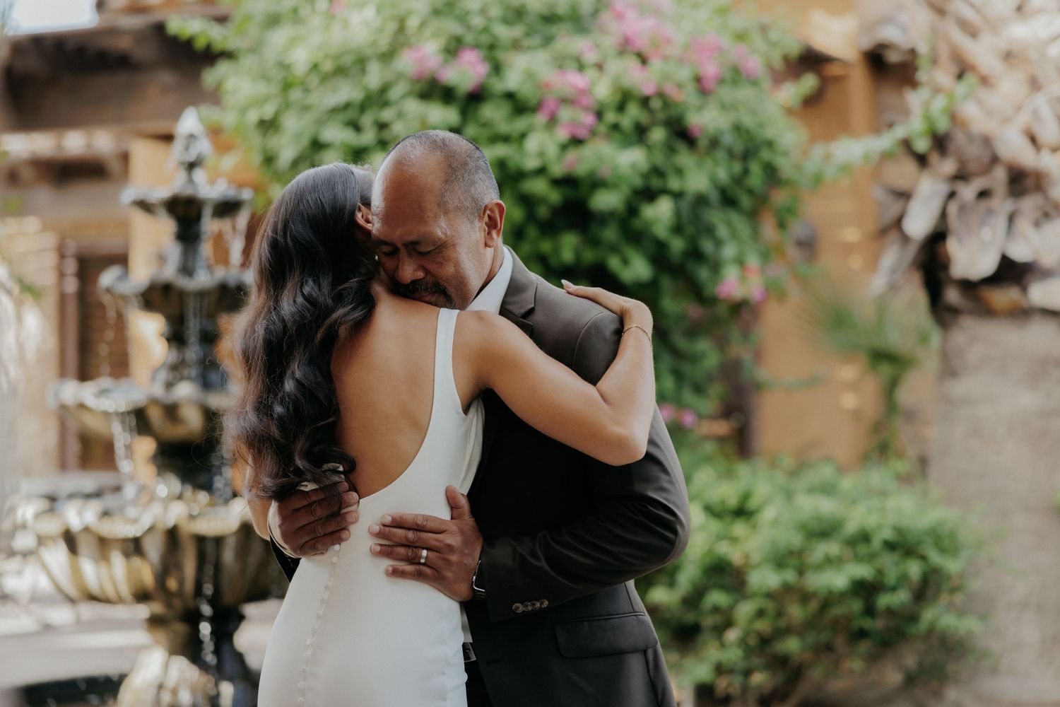A romantic couple shares tender moments in a lush garden setting during their wedding celebration.