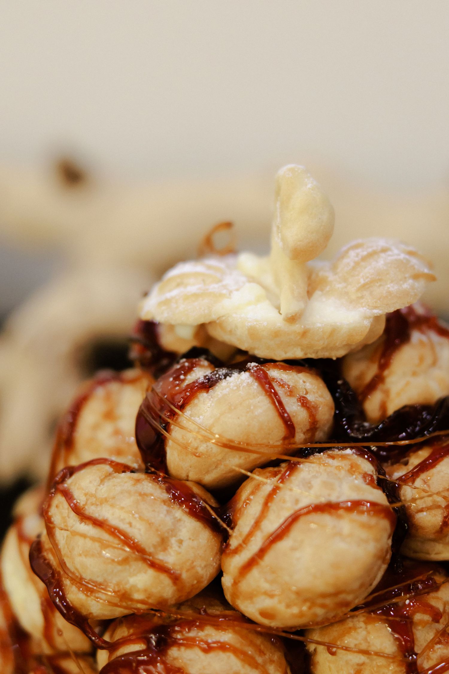 Close-up view of meringue cookies drizzled with chocolate sauce arranged on a light surface.