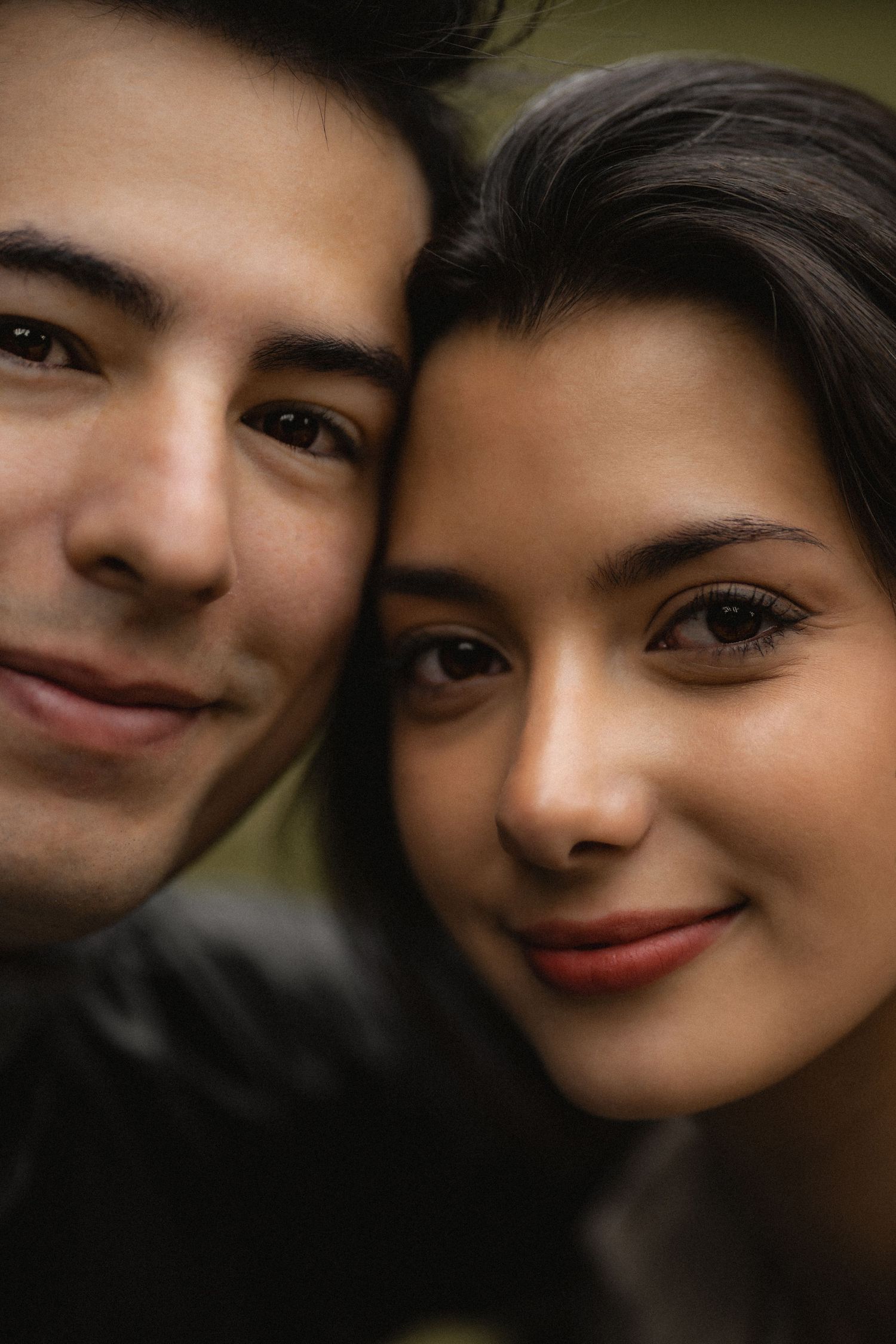 Close-up portrait of a couple sharing an intimate moment with soft lighting and warm expressions.