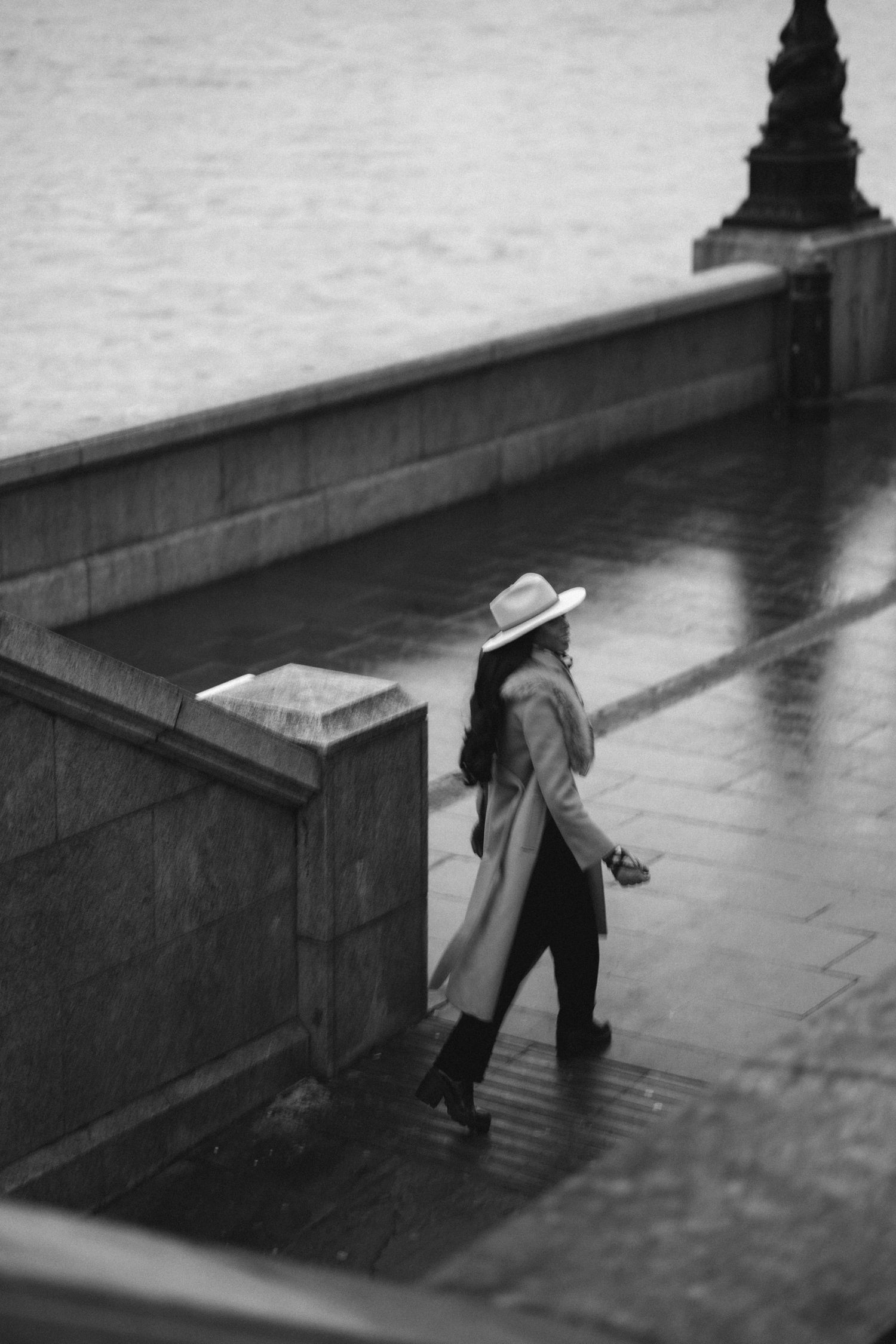 A black and white sequence shows a person in a hat walking past a bench, creating a minimalist street scene.