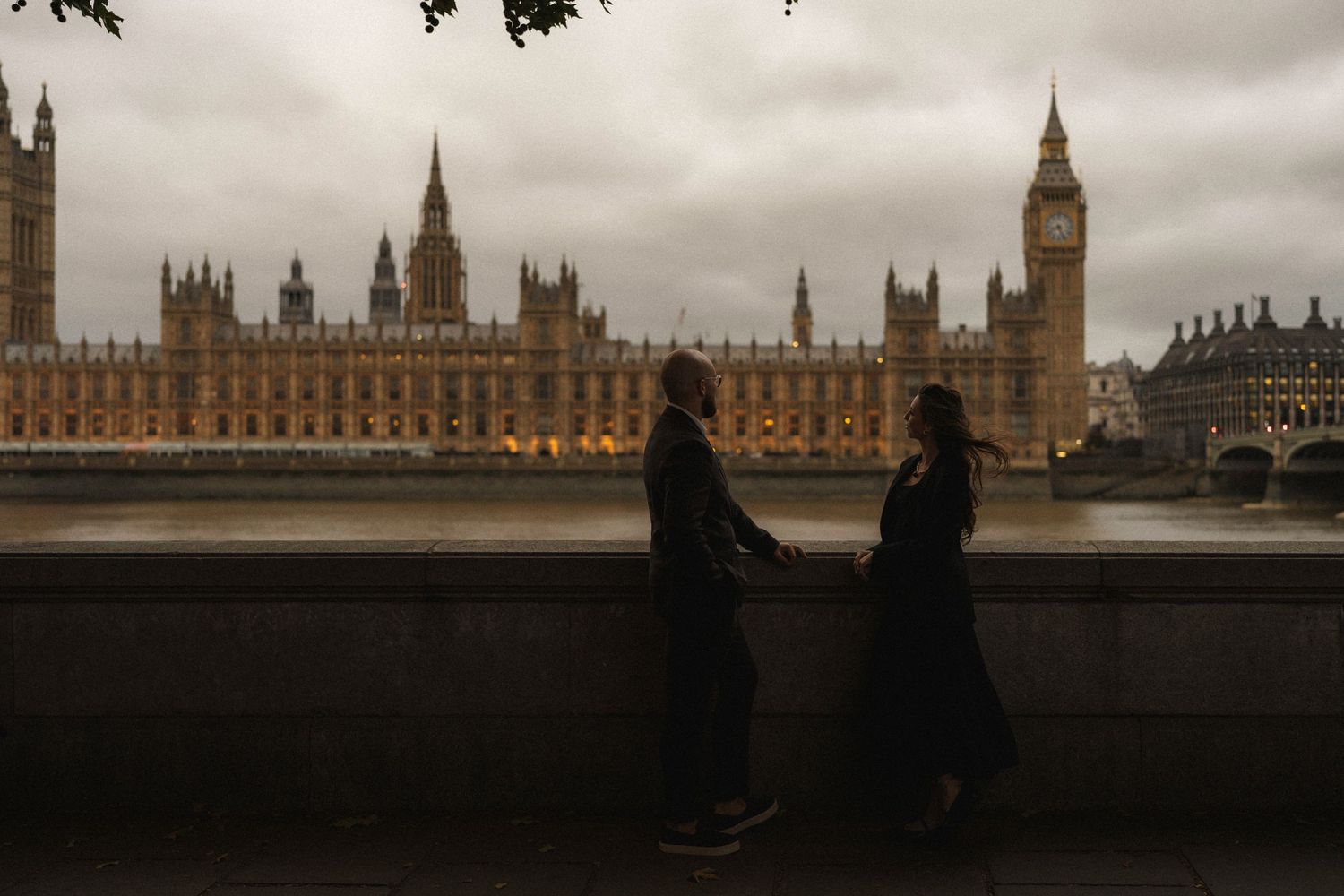 A moody panoramic collage of London's Houses of Parliament and Big Ben under dramatic cloudy skies.