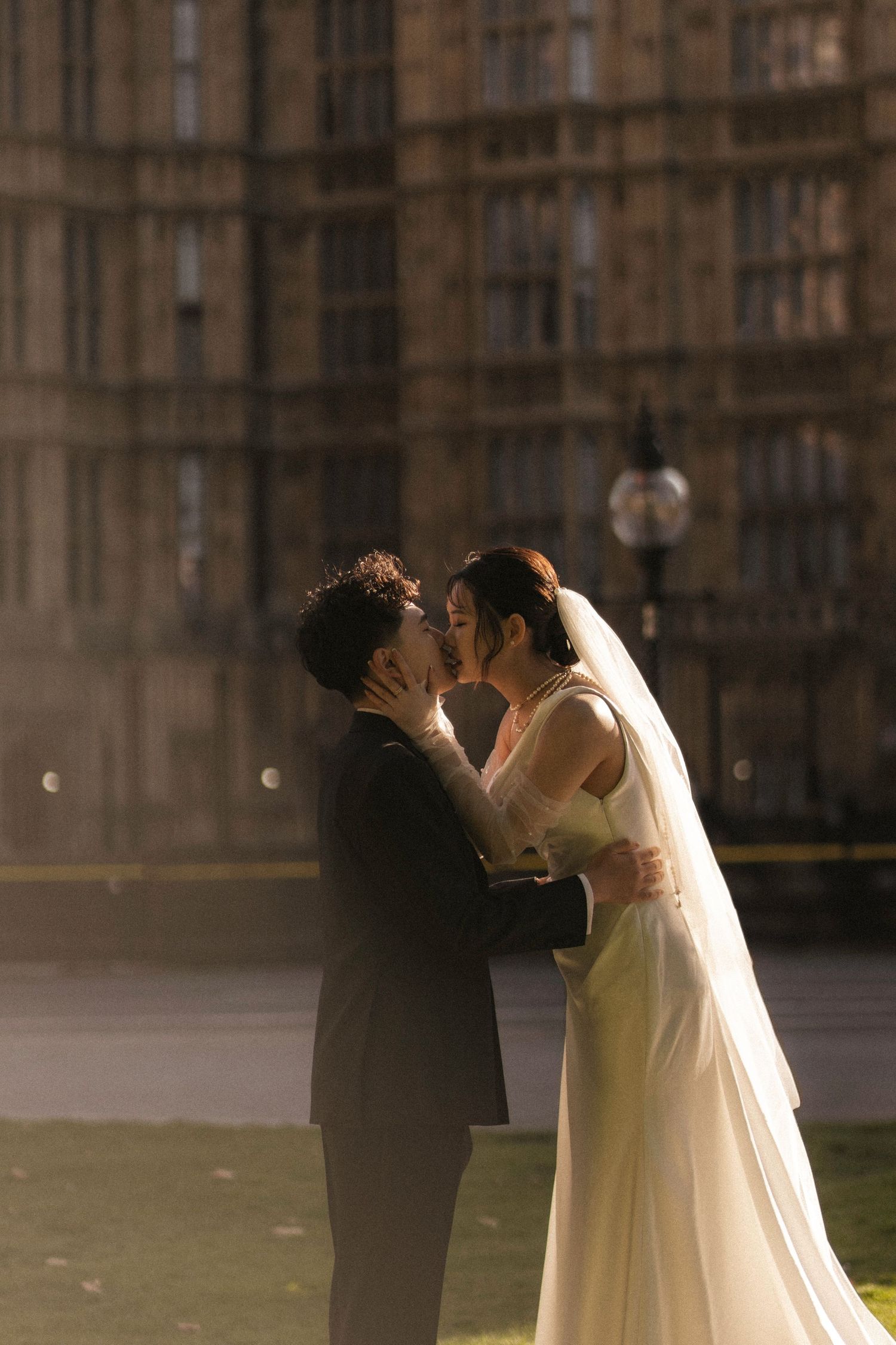 A bride and groom share a romantic kiss in front of the Houses of Parliament in London.