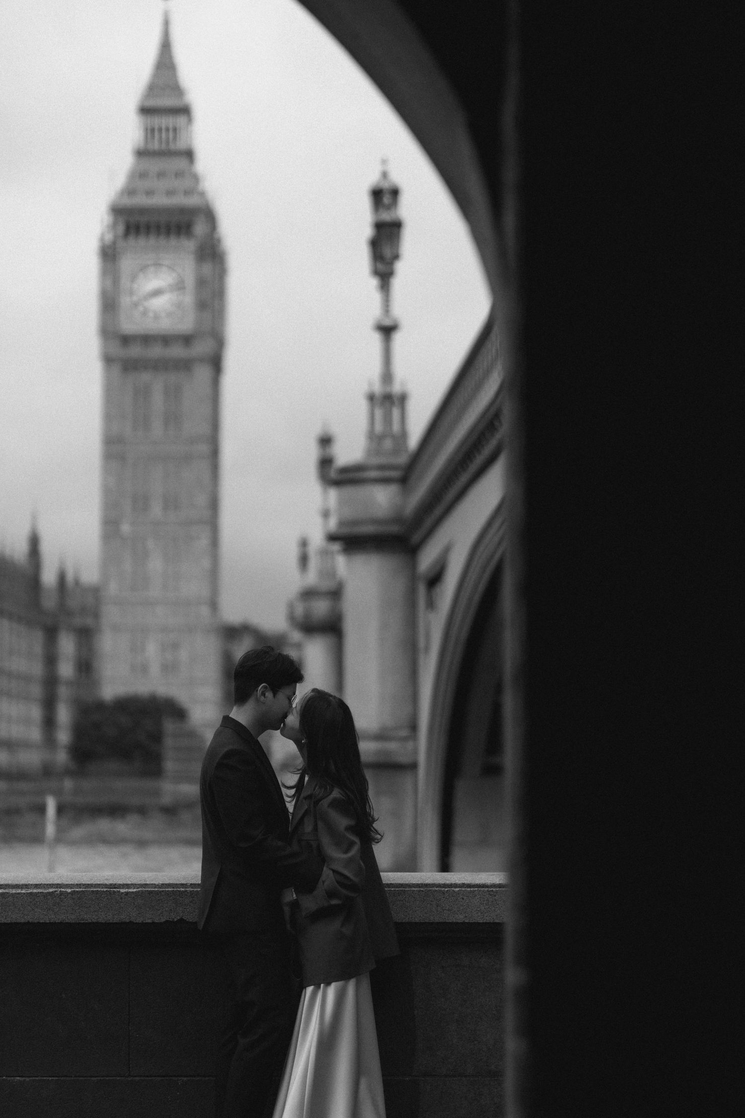 A romantic couple embraces near Big Ben in London, captured in black and white across four sequential frames.