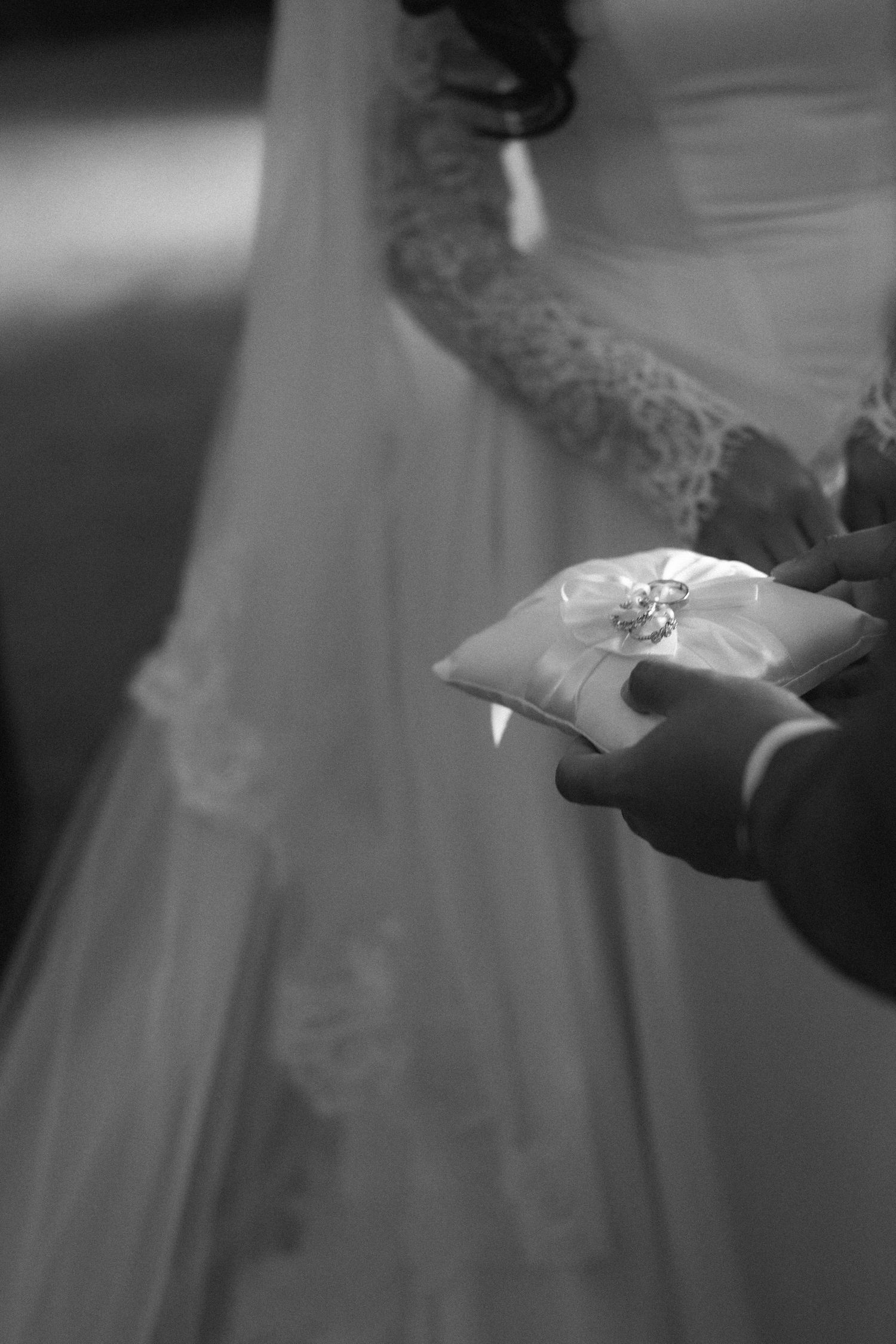 A series of black and white wedding ring photos showing close-up details of ring exchanges during a ceremony.