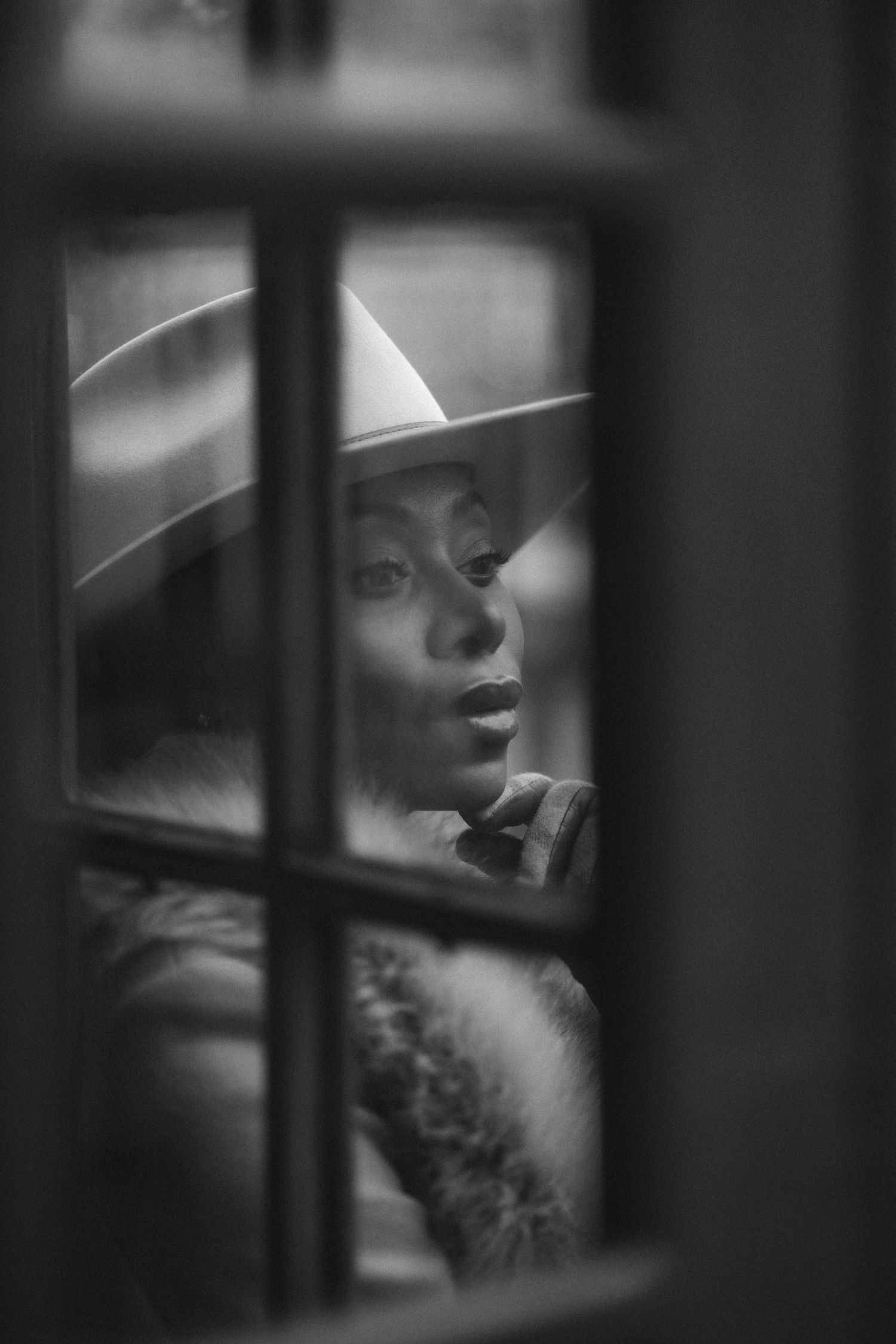 Artistic black and white portrait series showing a figure behind window panes creating a dramatic moody effect.