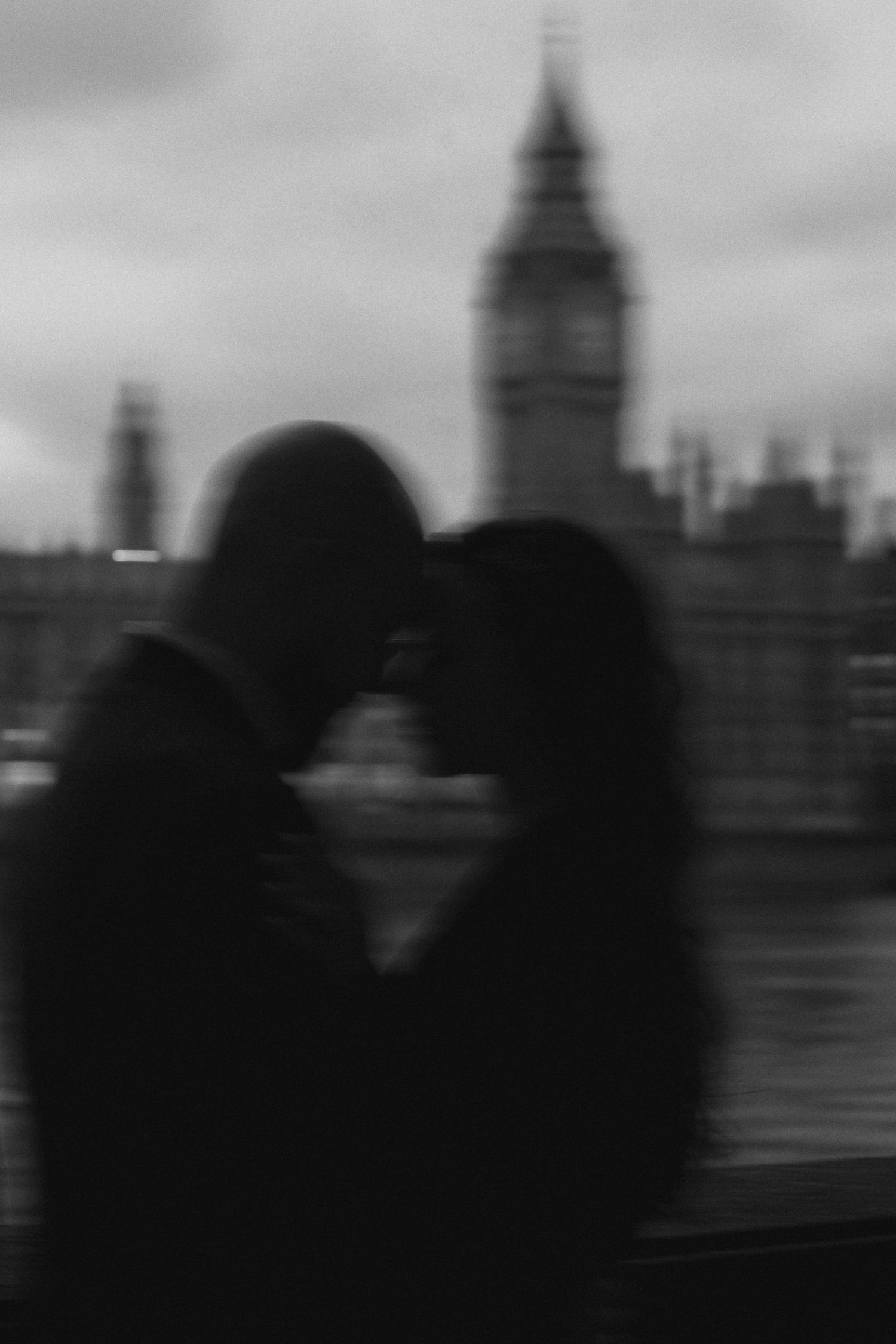 A sequence of blurred black and white images showing silhouettes against a city skyline with buildings and towers.