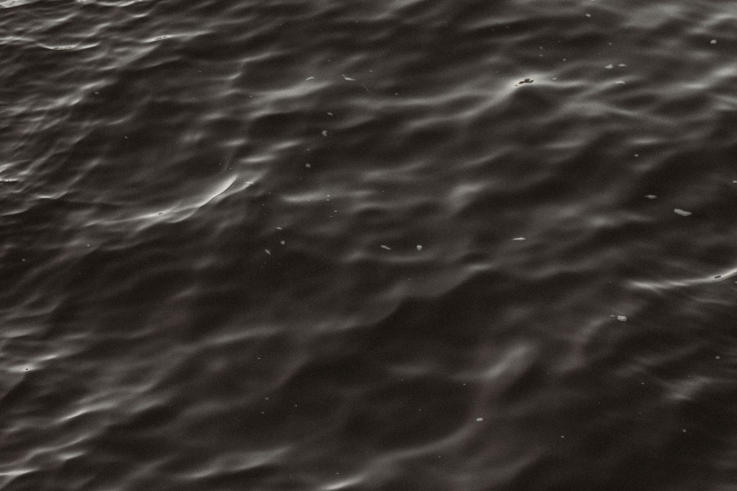 Aerial view of dark ocean waves rippling across the water's surface in a mesmerizing pattern.