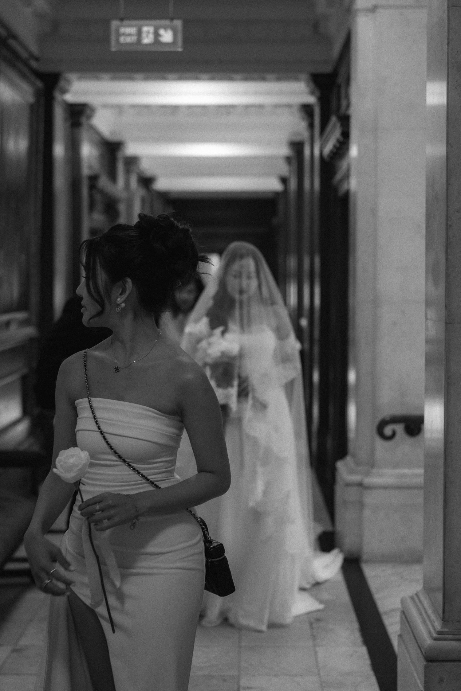 A black and white photo series showing a bride and groom dancing together in an elegant hallway.