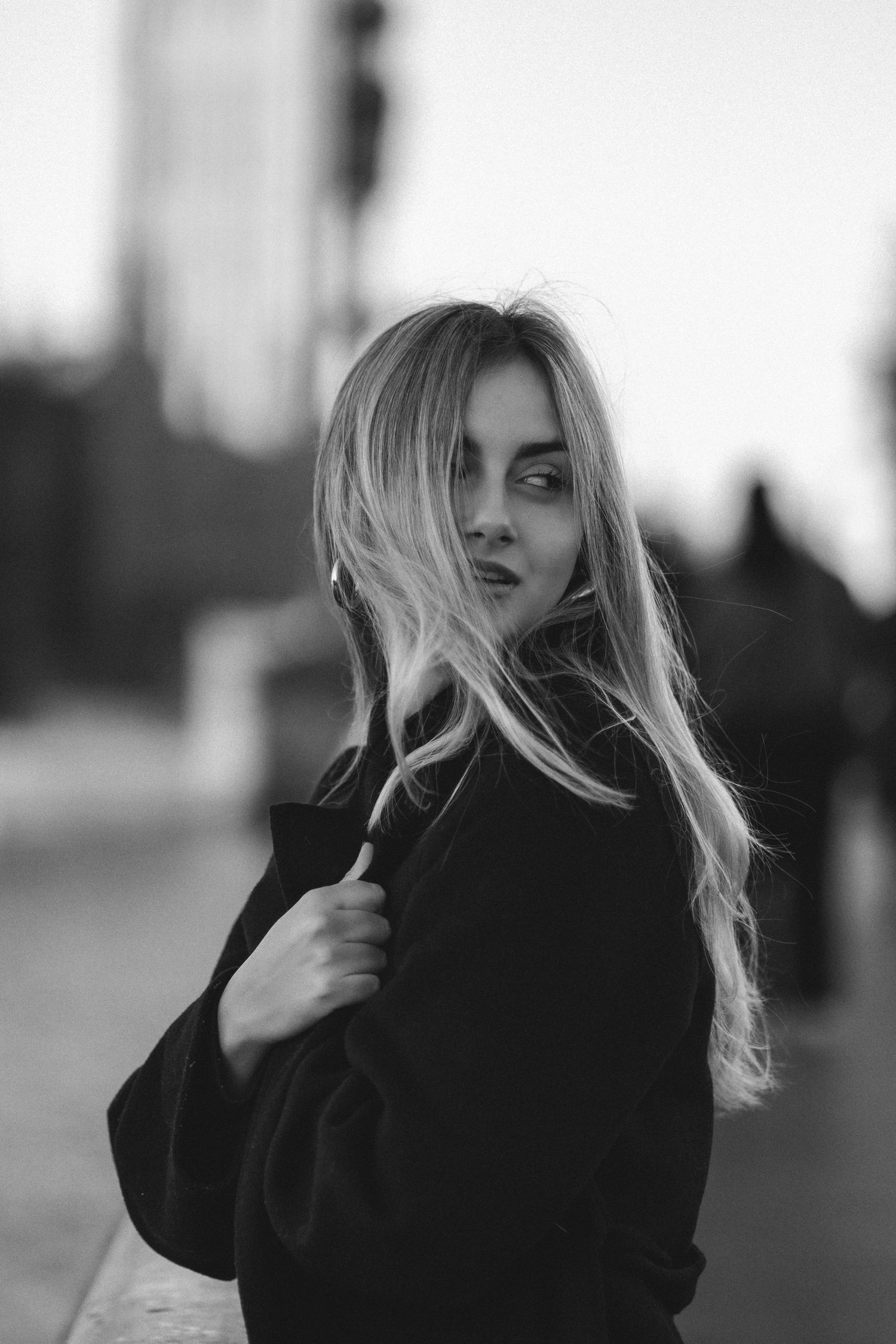 Artistic black and white portrait series showing flowing blonde hair movement against dark clothing in moody lighting.