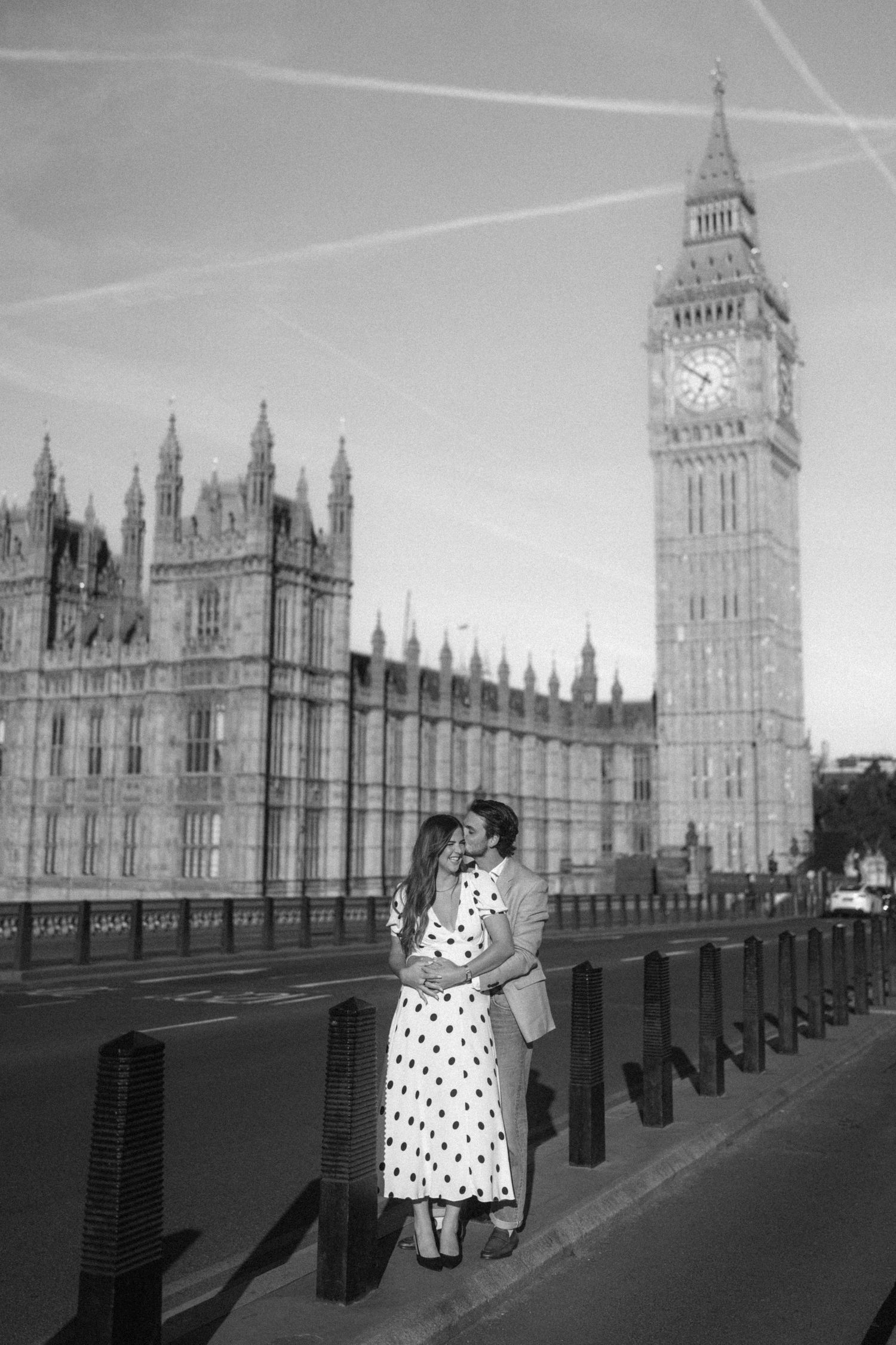 Couple embracing romantically in front of Big Ben and Houses of Parliament, London, black and white photo.