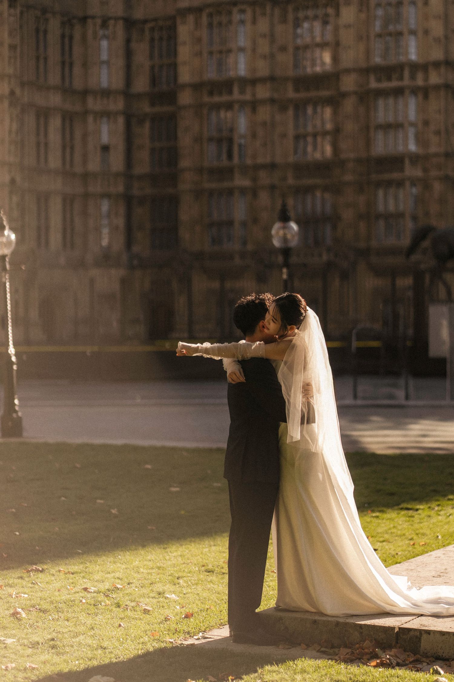 Bride and groom embracing outside the Houses of Parliament in London on their wedding day.