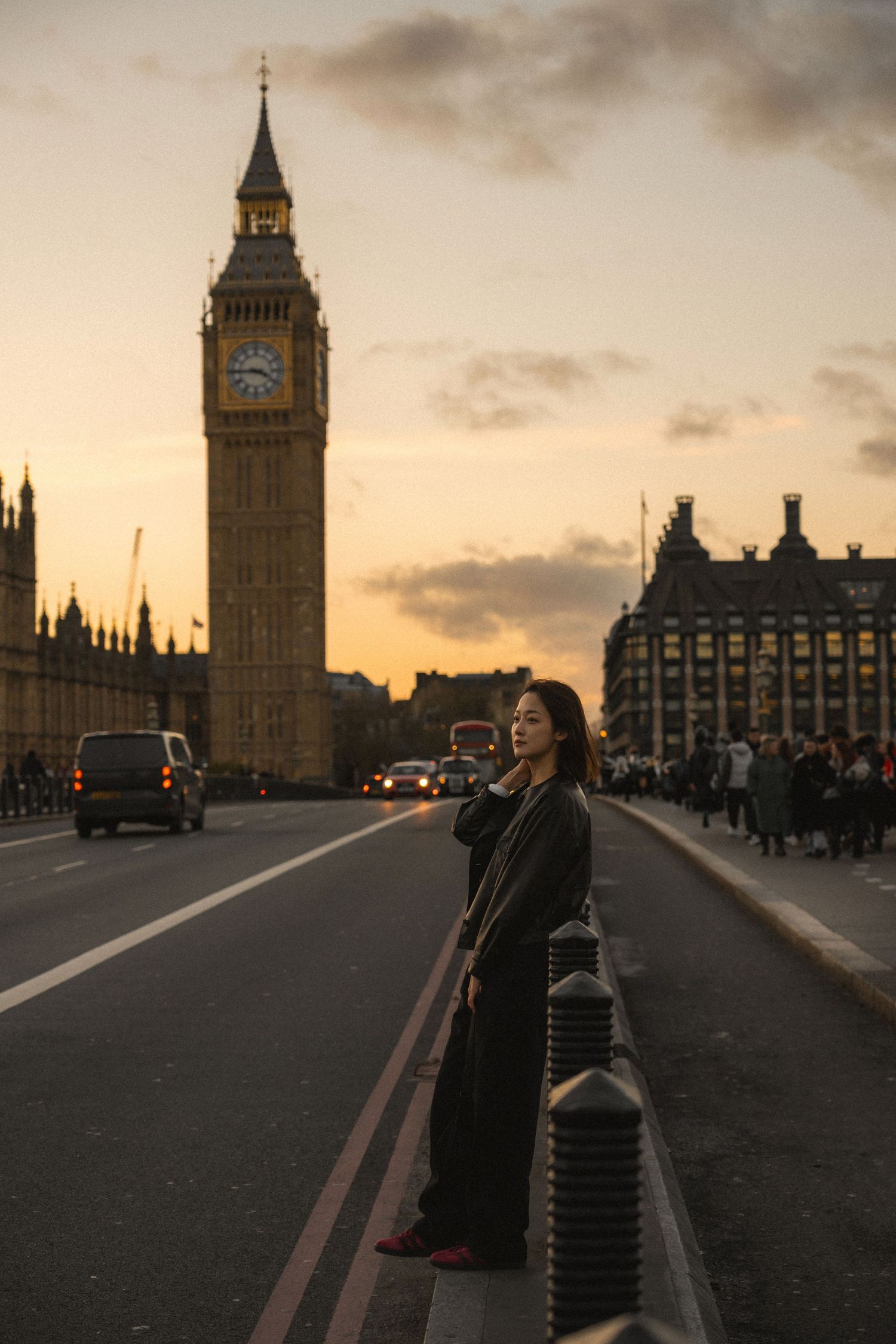 Silhouette of a person standing on Westminster Bridge at sunset with Big Ben and Parliament buildings in London.