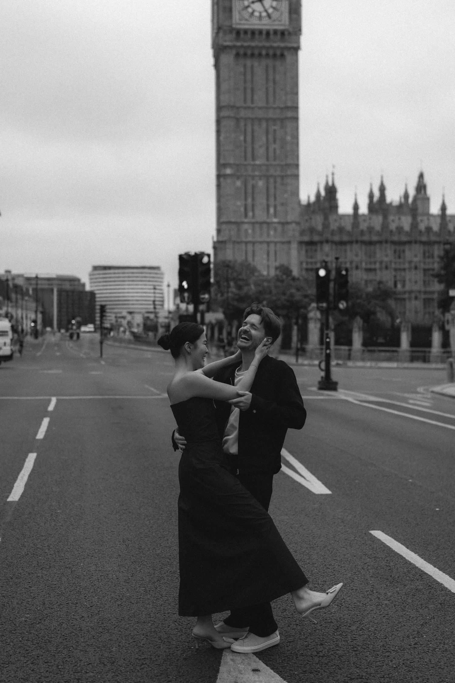 Two figures dance joyfully on Westminster Bridge with Big Ben and Parliament buildings visible in the background.