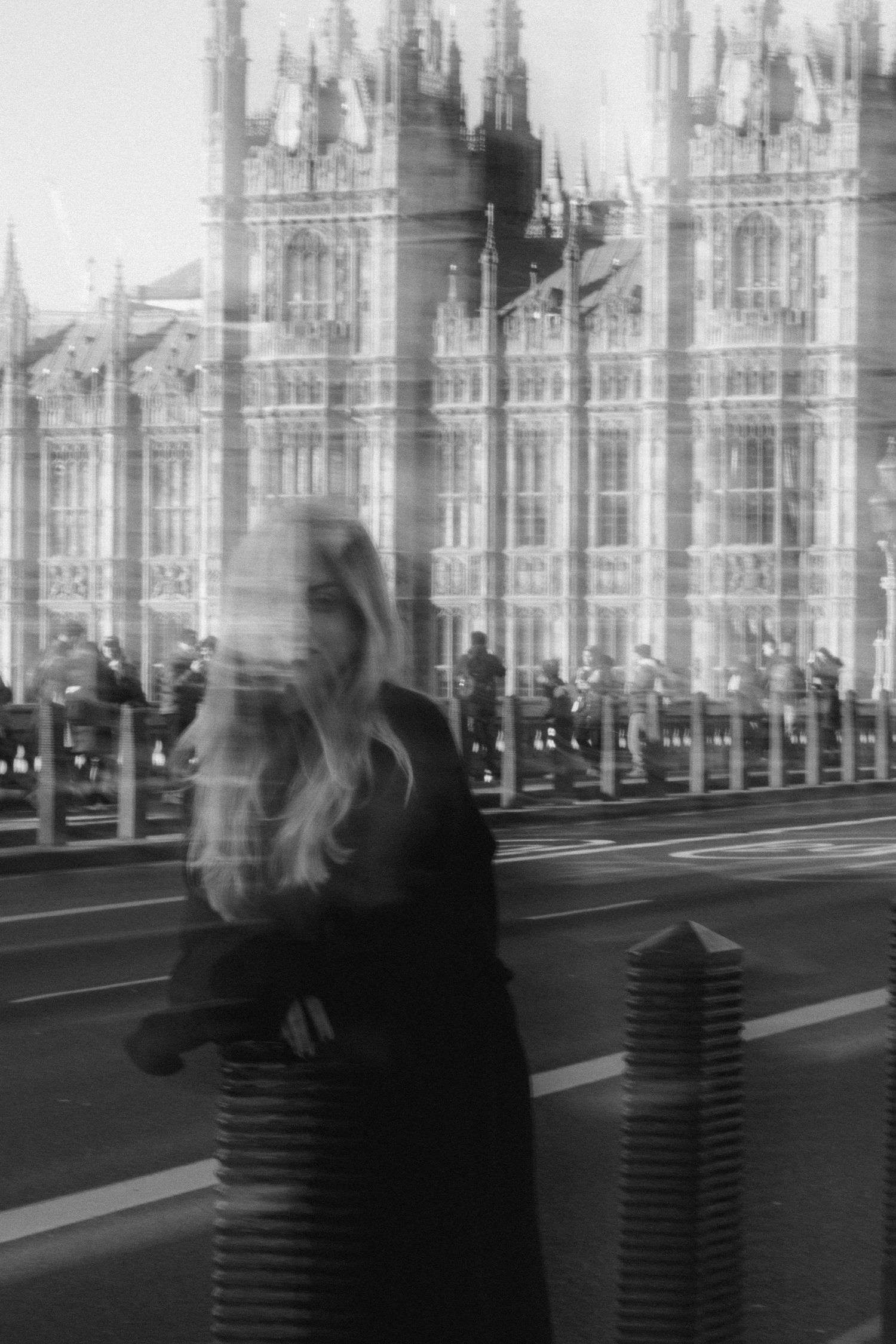 A sequence of black and white photographs showing motion blur of people walking past ornate Gothic architecture.