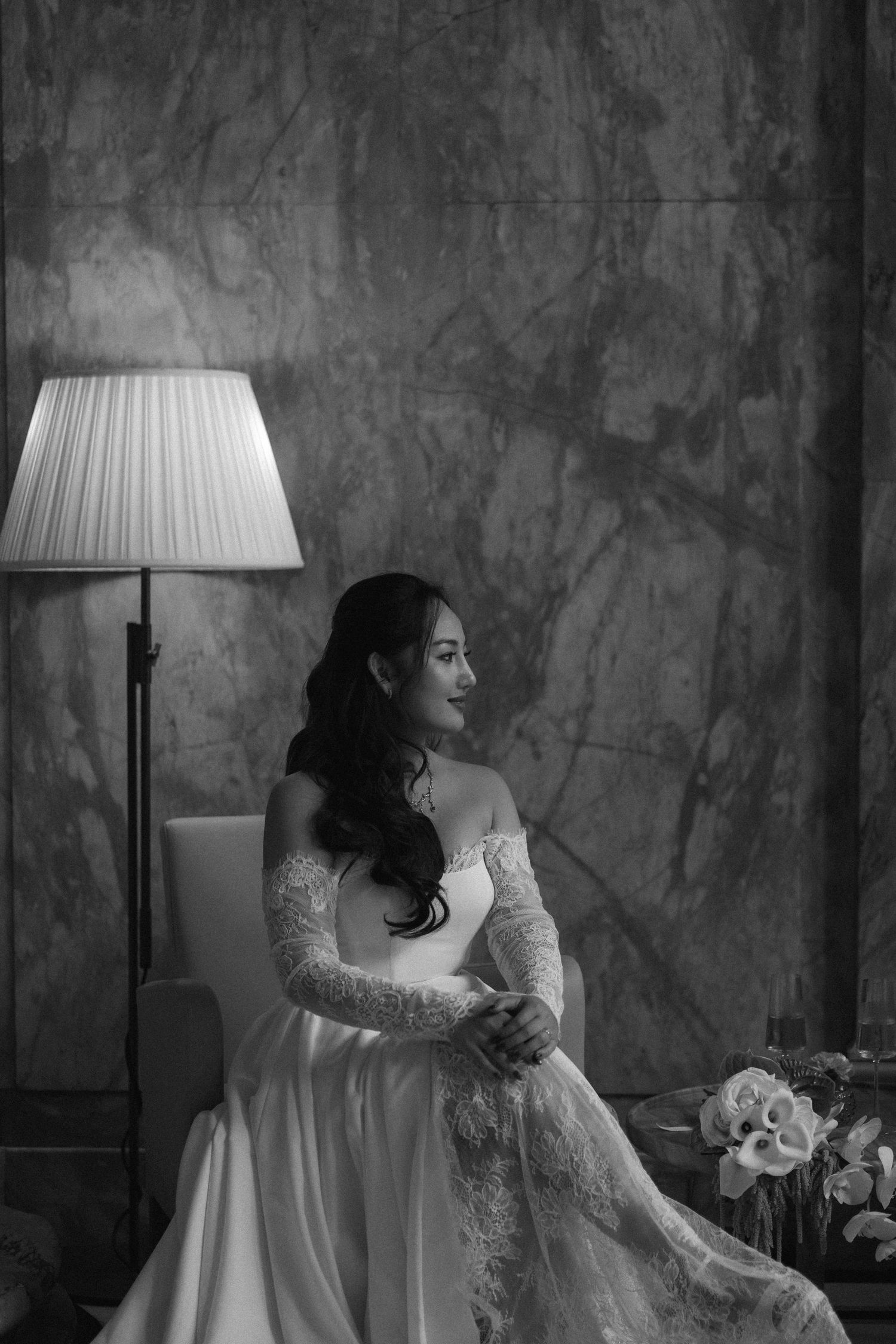 A black and white artistic photo series showing a figure in a white lace dress sitting by a lamp against a textured wall.