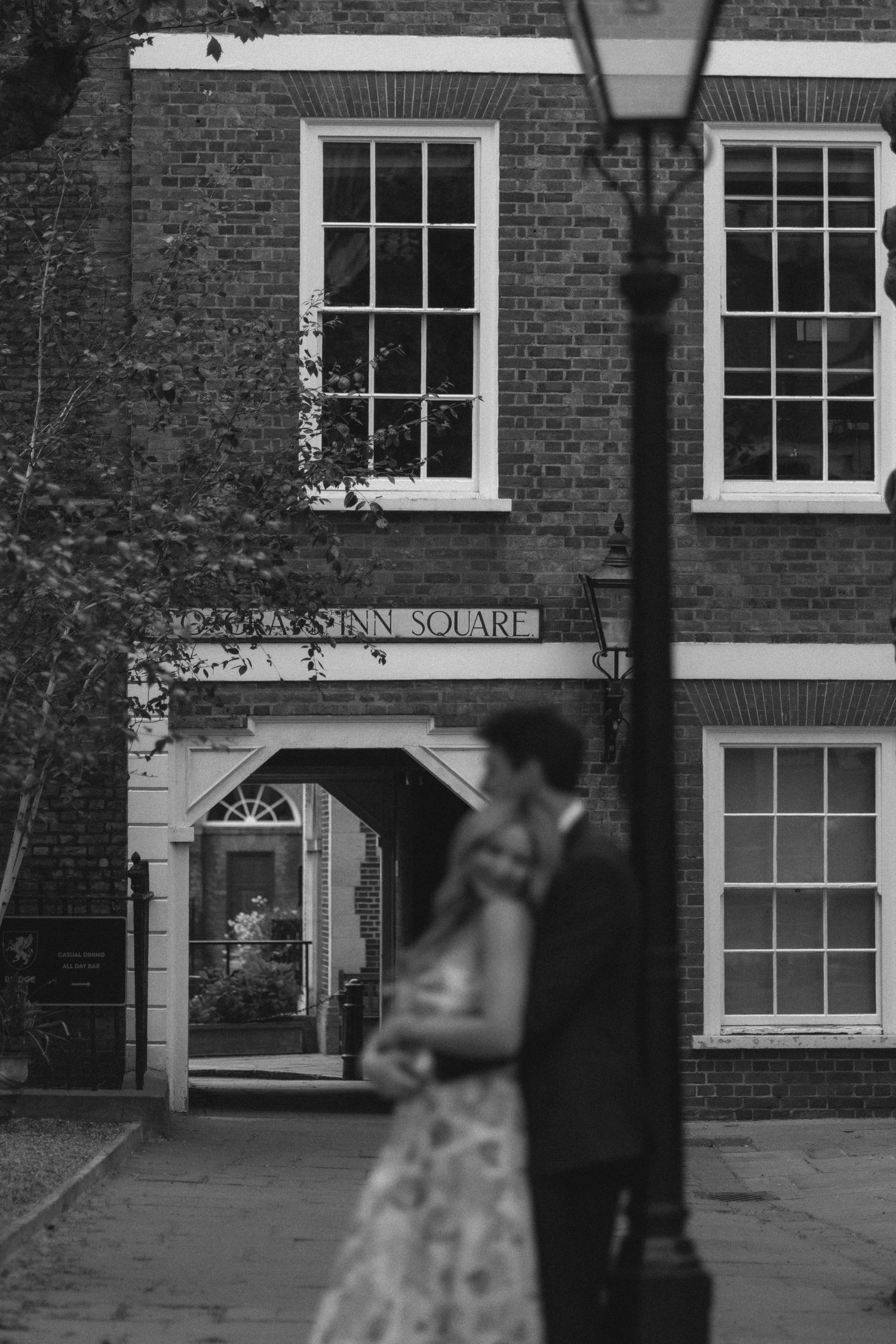 Exterior view of a traditional brick building with white-framed windows and a sign reading 'Inn Square'.