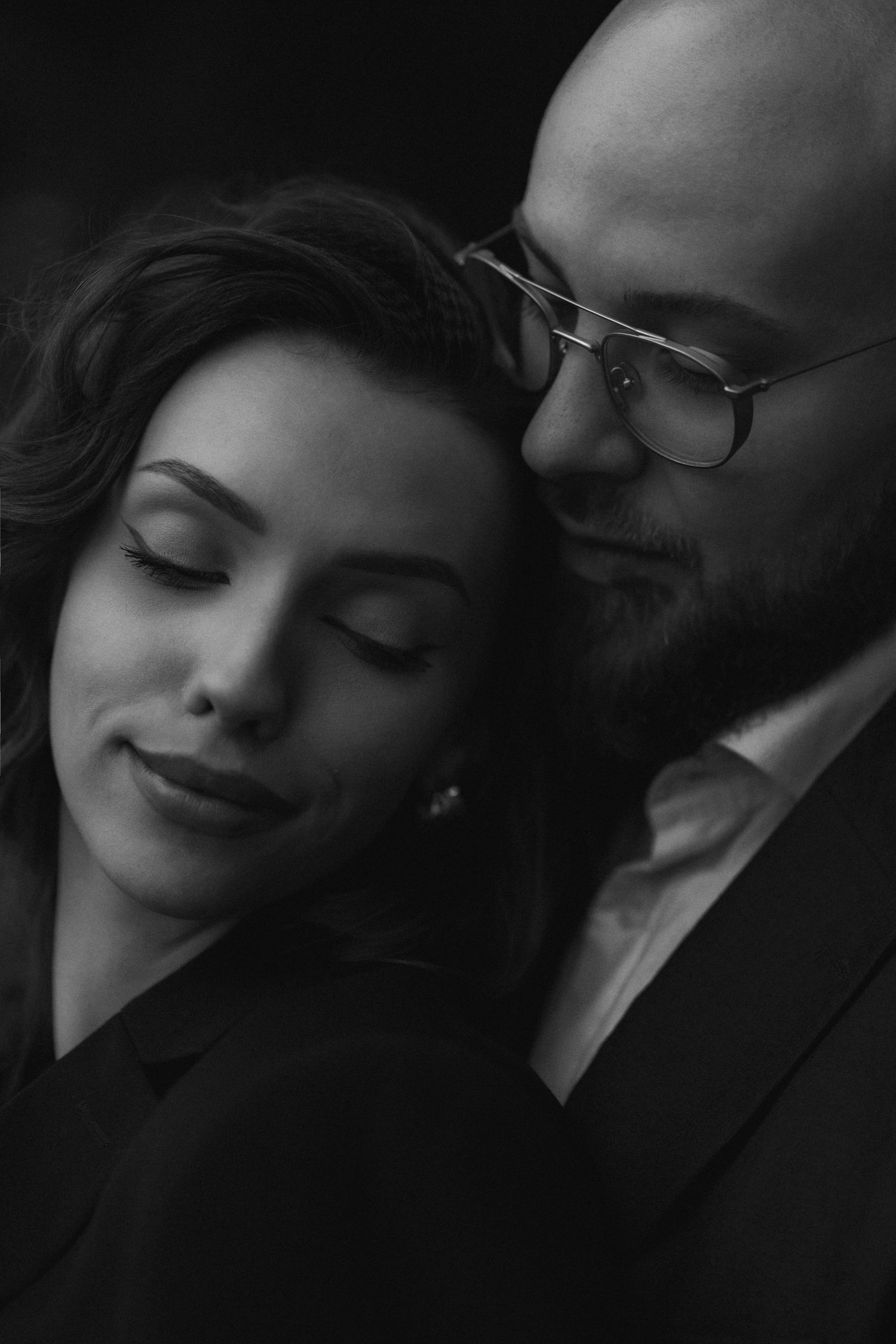 A romantic black and white photo series showing a couple in an intimate embrace with closed eyes and gentle expressions.