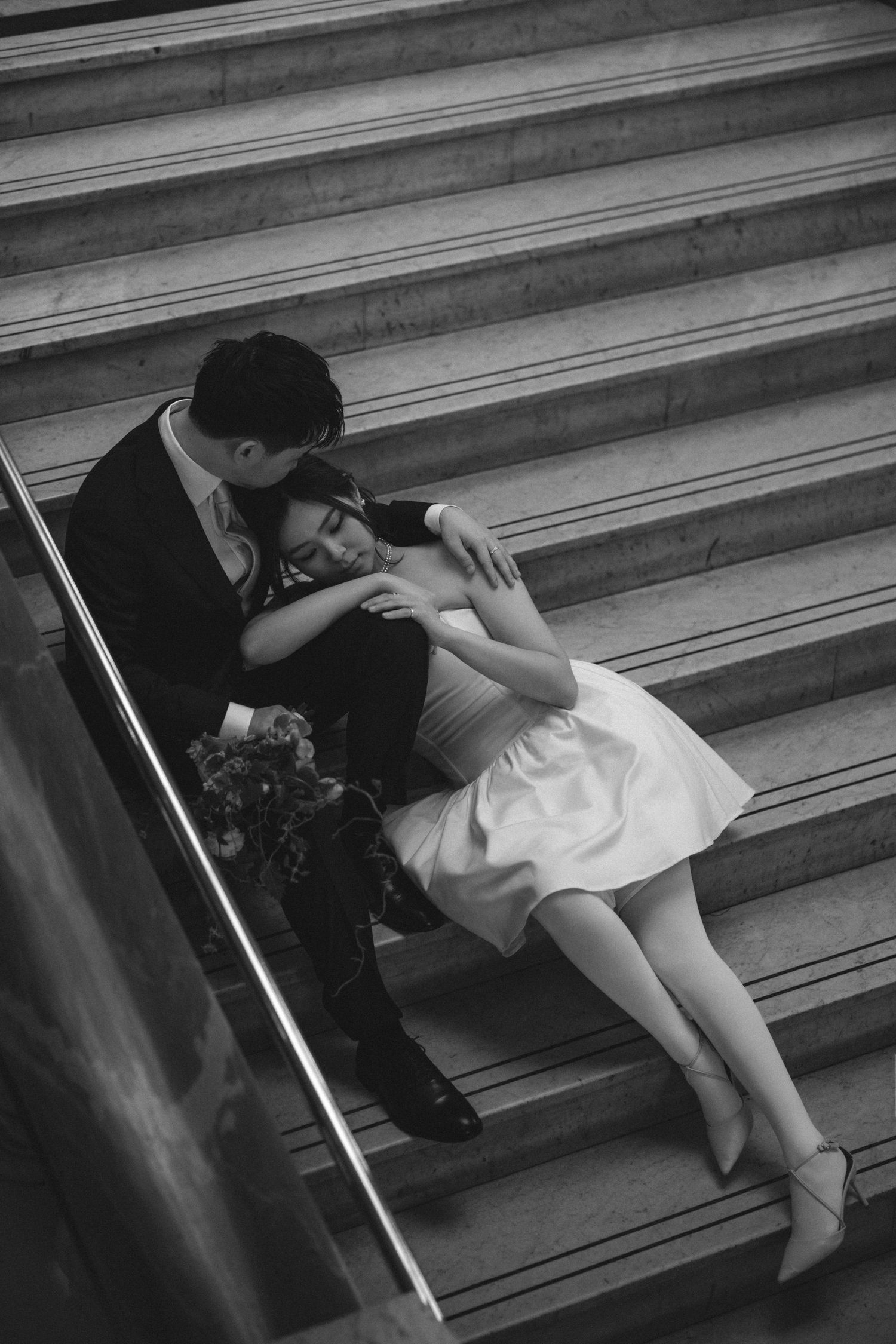 A black and white photo series shows a person lying on concrete steps in various relaxed poses.