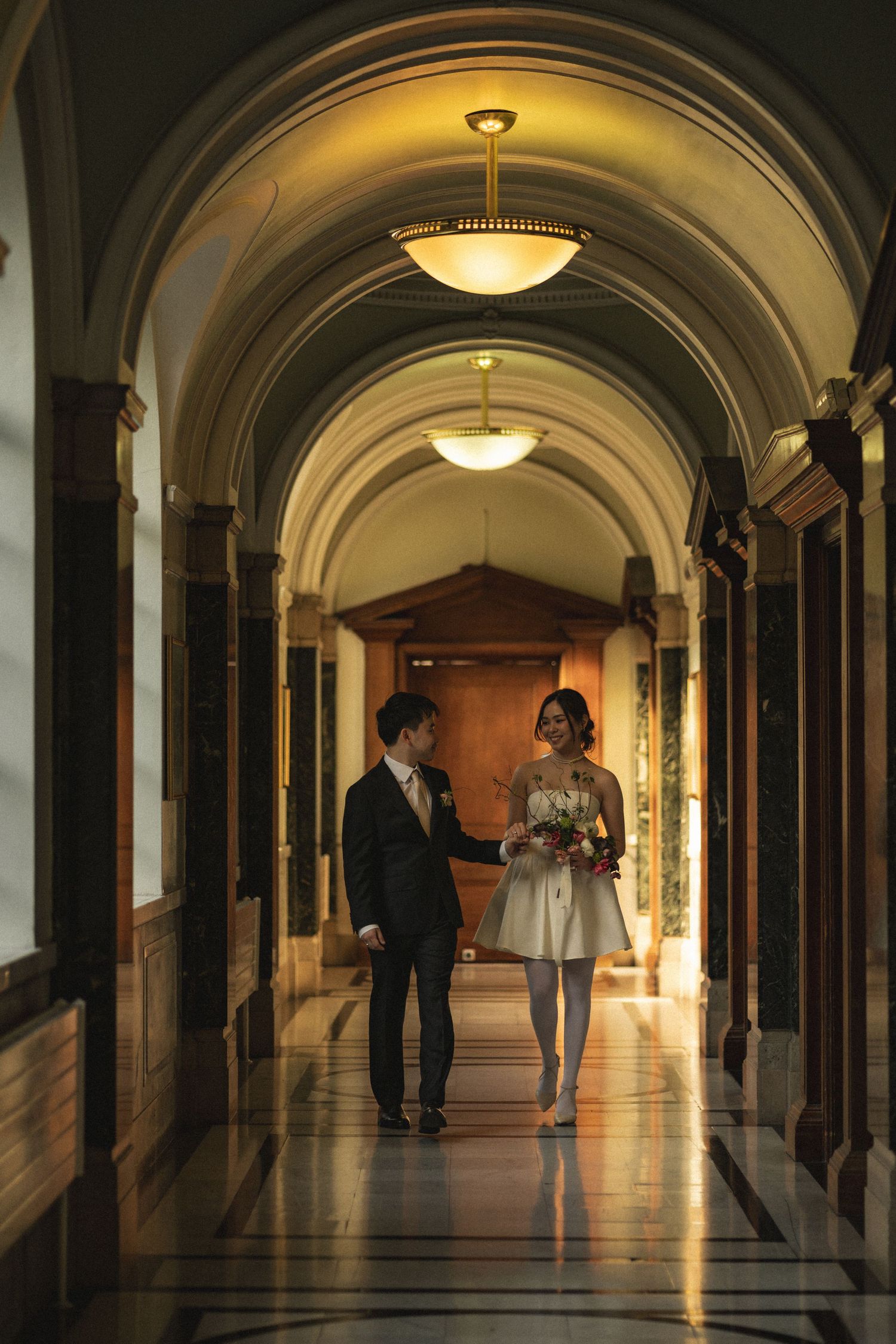 Four sequential photos showing silhouettes of people walking through an elegant arched hallway with warm lighting.