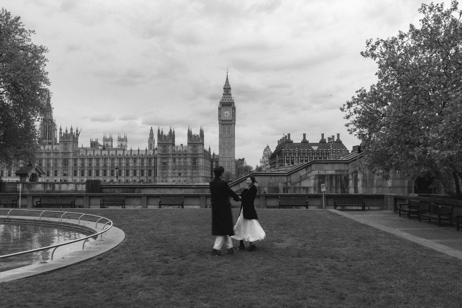 Historic black and white panoramic view of London's Houses of Parliament and Big Ben from Westminster Bridge.