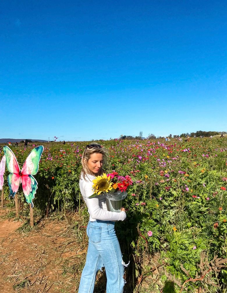 Athena Arnold travel photographer in Northern Maryland enjoying a flower patch.