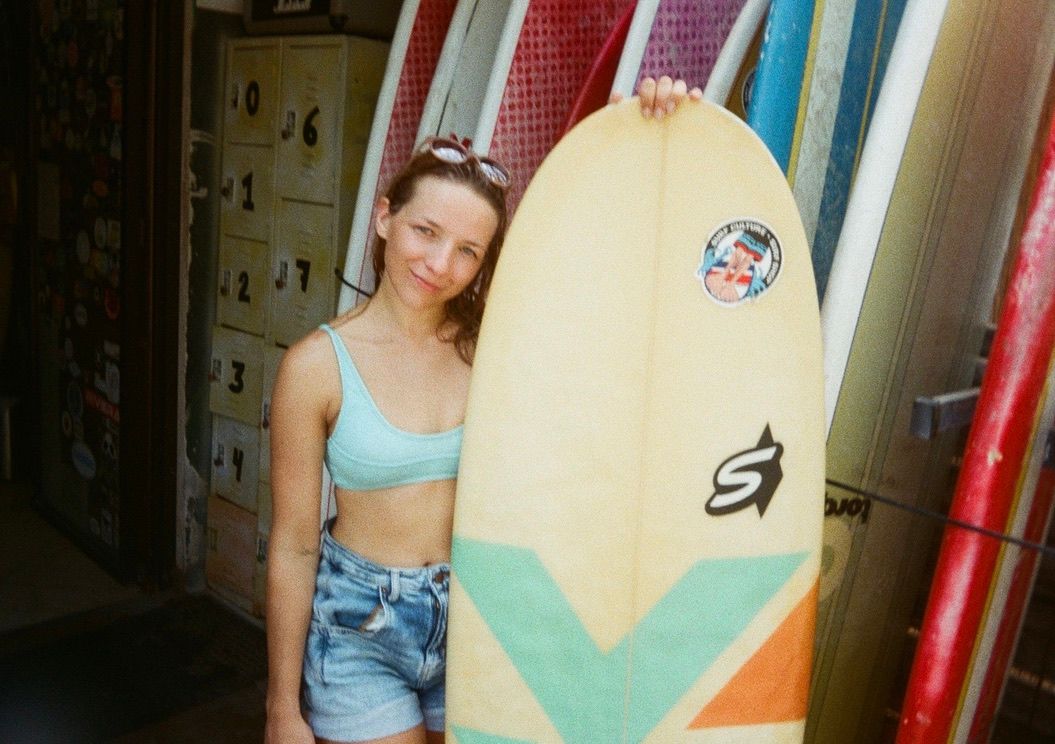 Athena Arnold travel and adventure photographer on 35mm film getting ready for surf lesson in Costa Rica.