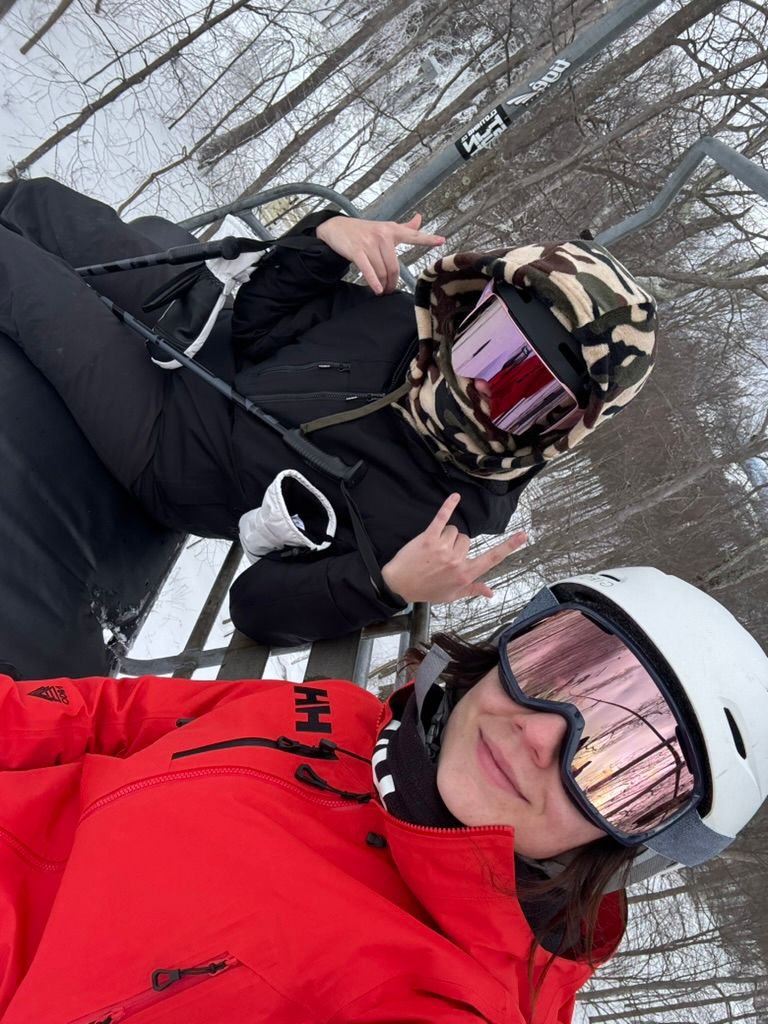Athena Arnold adventure photographer in northern maryland on a ski lift ready to hit the slopes.