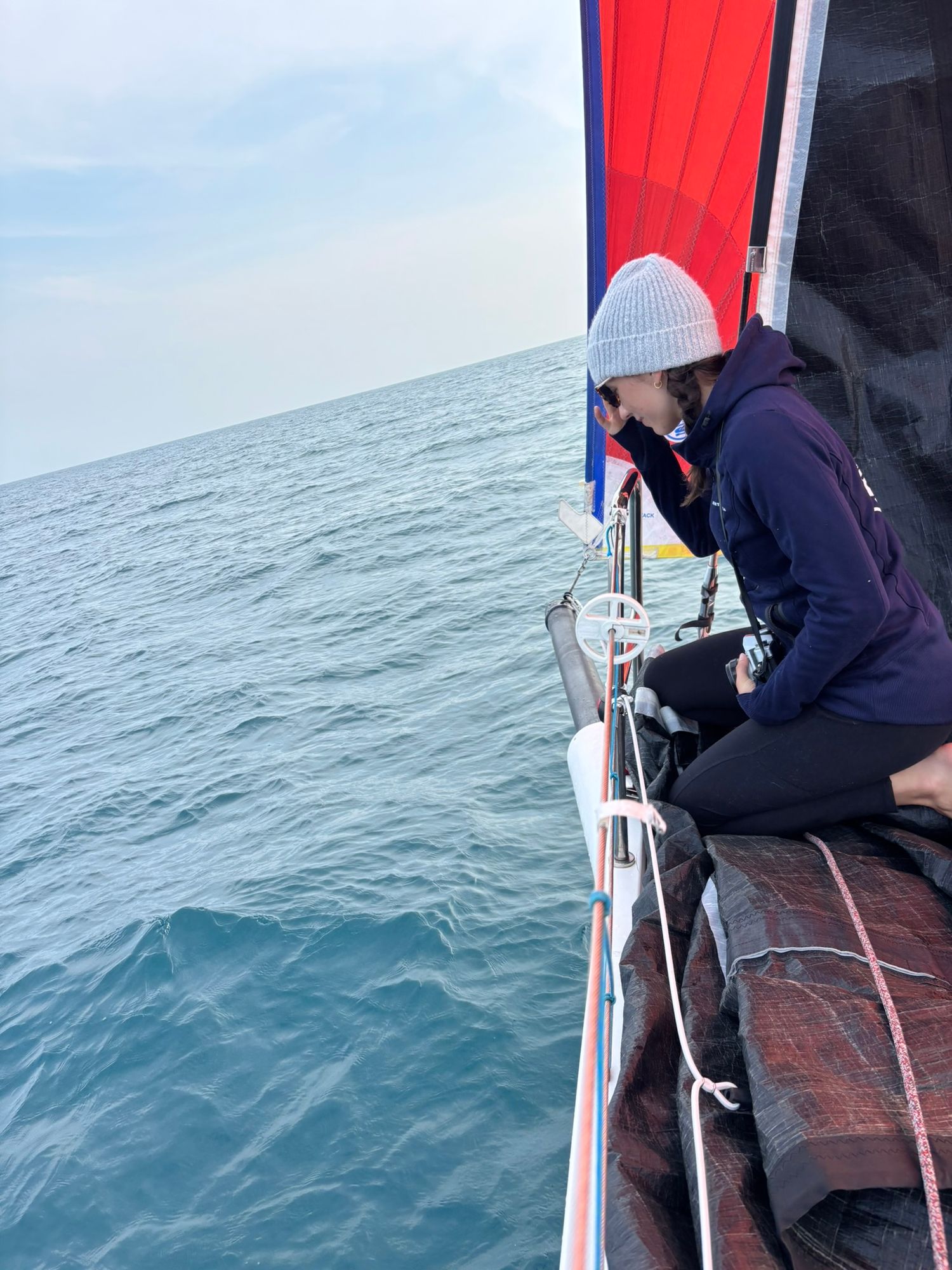 Central Florida Travel photographer Athena Arnold waits to photograph dolphins on the bow of. a sailboat in the Atlantic ocean.