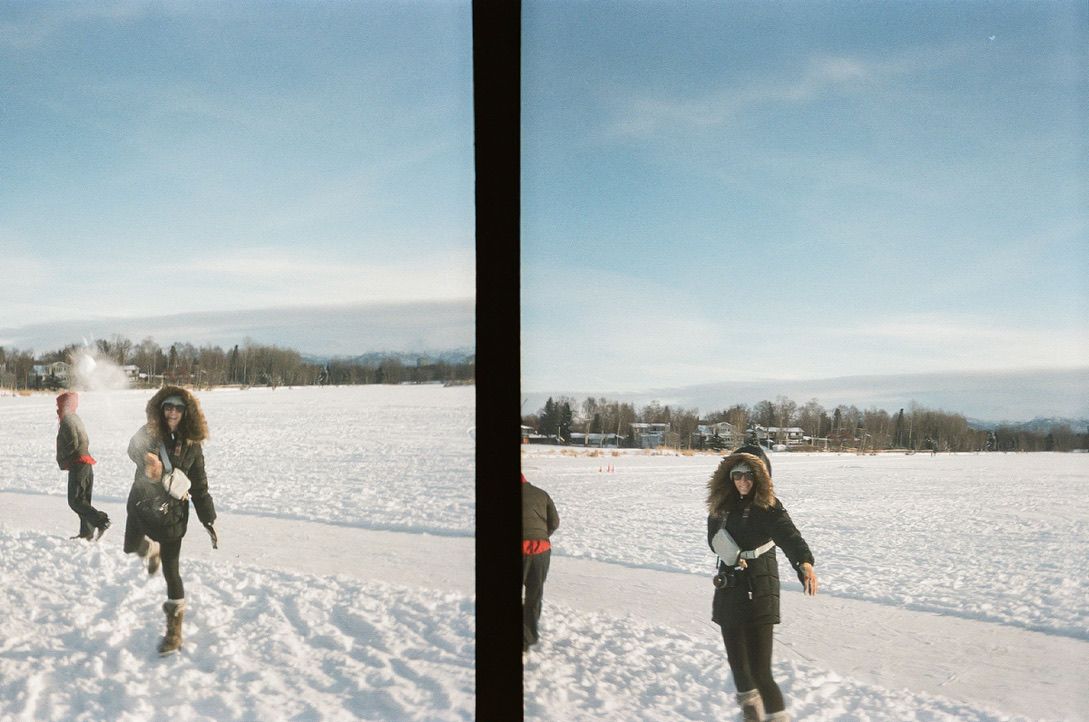 Athena Arnold Travel photographer having a snowball fight in Alaska on 35mm film.