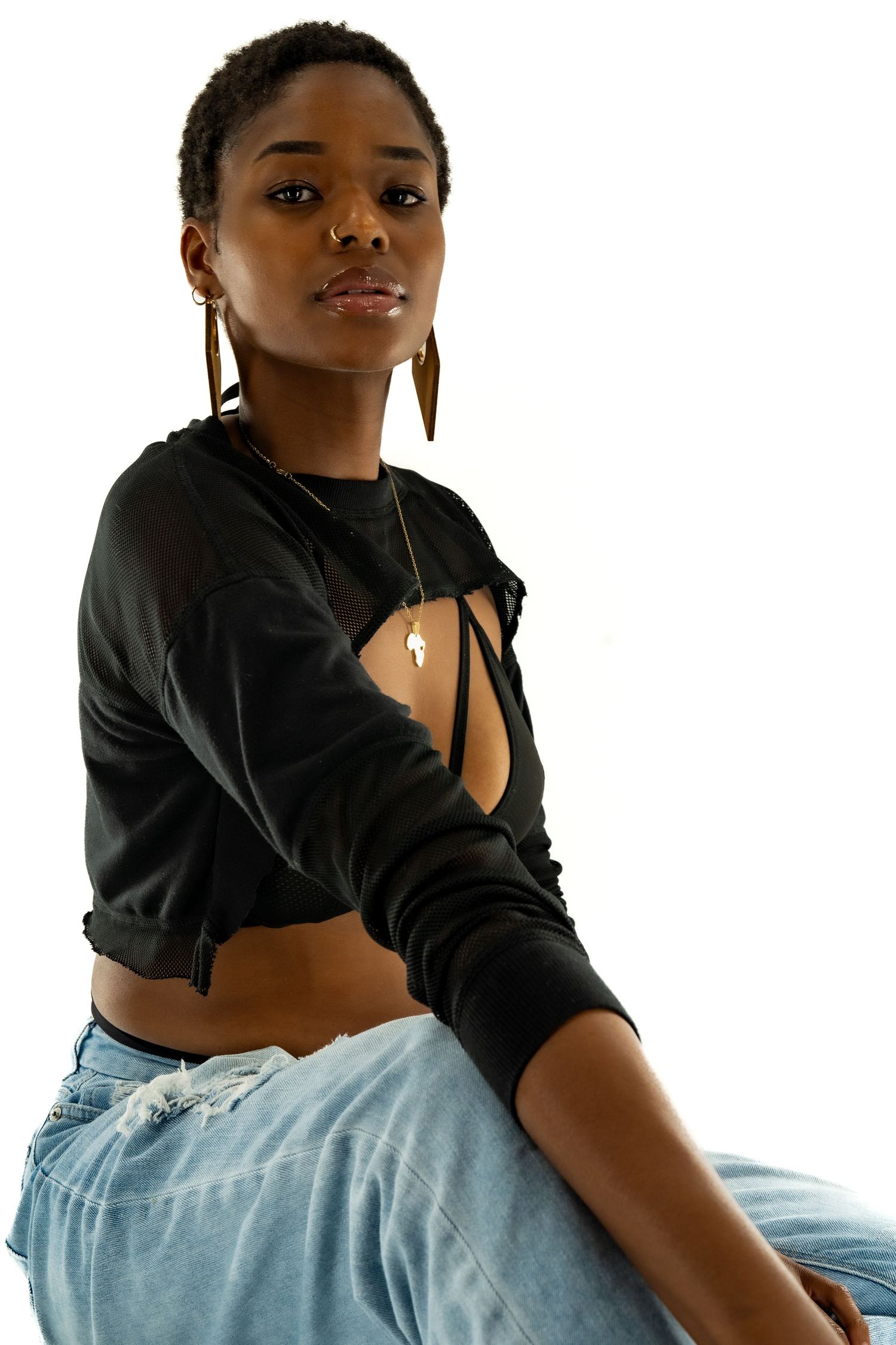 Fashion shot of model in cropped black sweatshirt and light denim jeans.