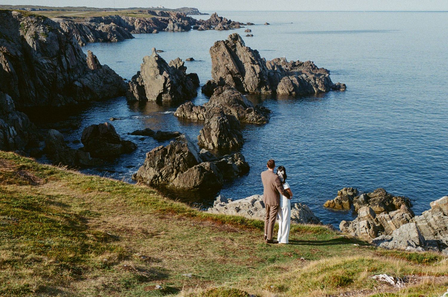 35 mm film photo of bride and groom embracing on rocky coastline during their Vancouver Island Elopement