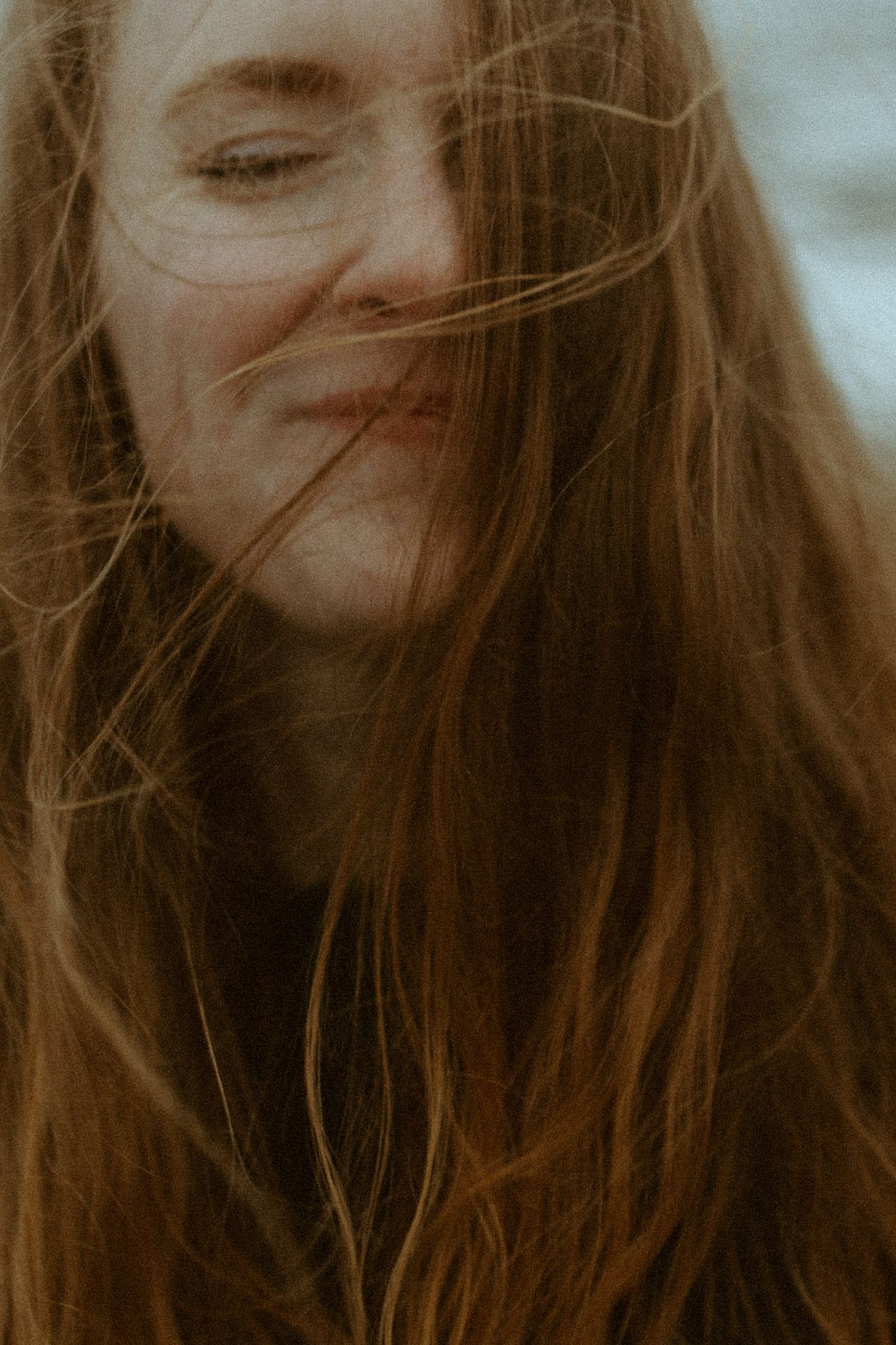woman laughs as the wind blows her hair around her during her Self Love Session