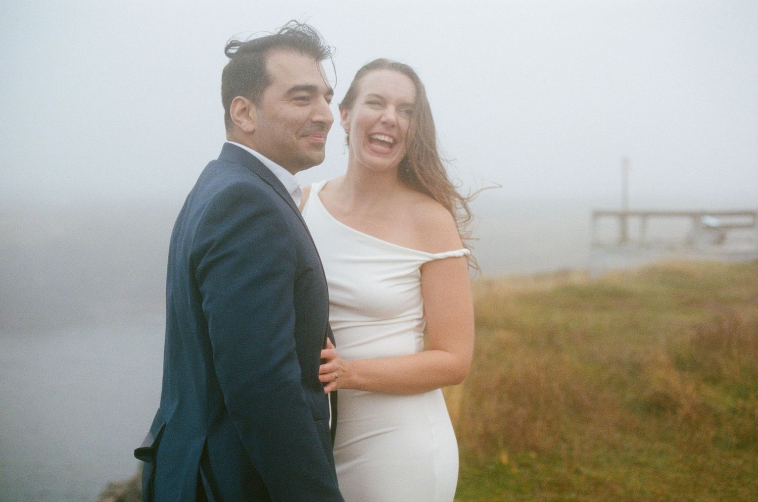35 mm film photo of bride and groom laughing in the mist during their Tofino elopement ceremony