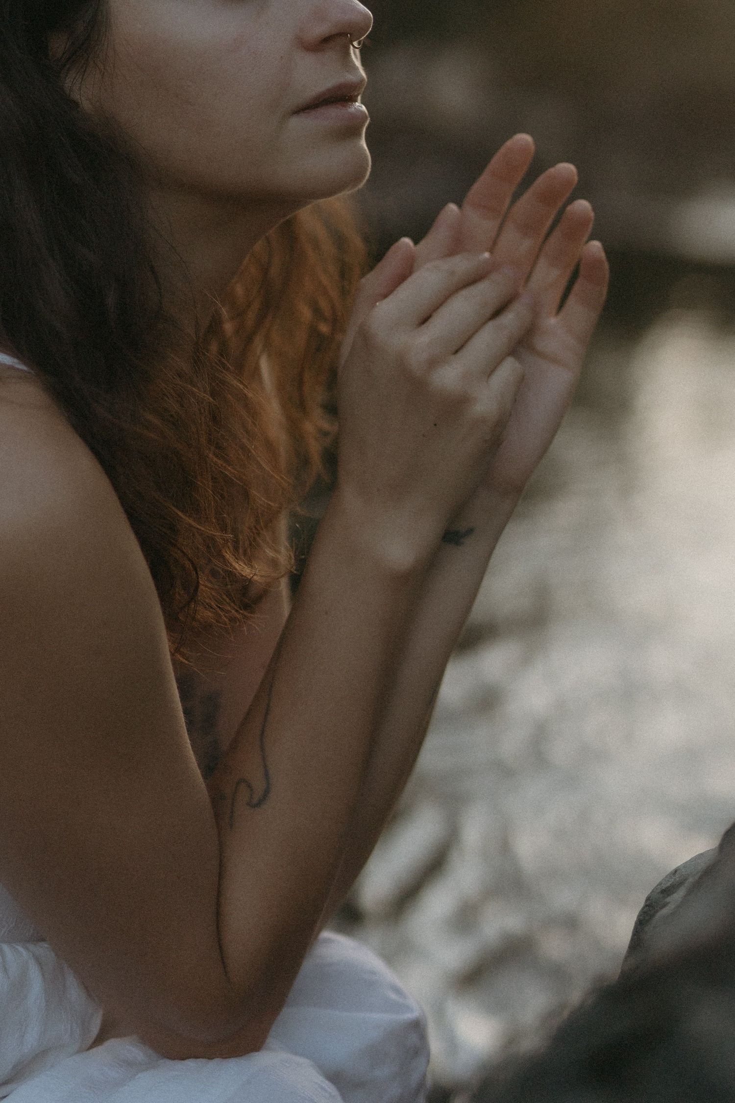 woman with a gentle expression bathes in a river in the evening light