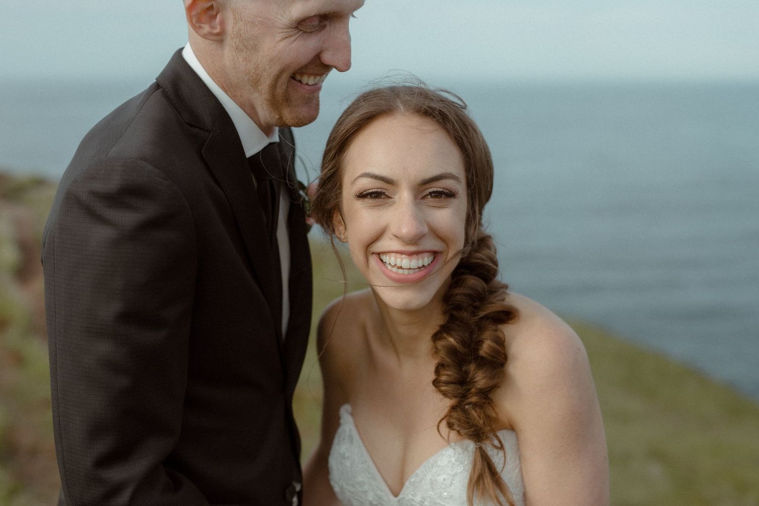 Bride and Groom laugh in a meadow by the coast during Tofino Elopement