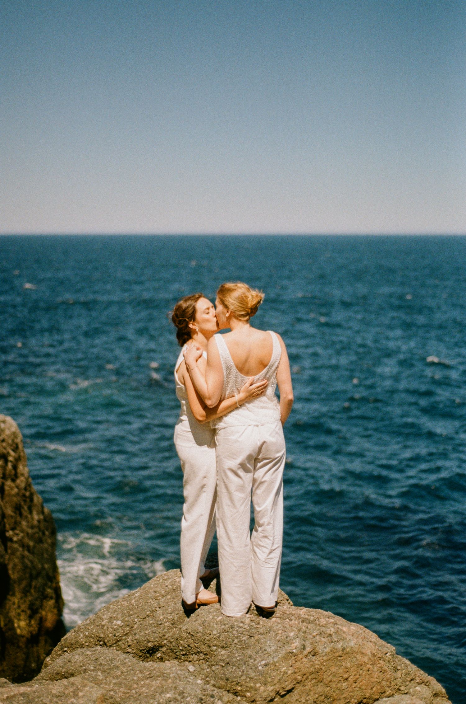 35 mm film photo of two brides kissing by the ocean during their Vancouver Island Elopement