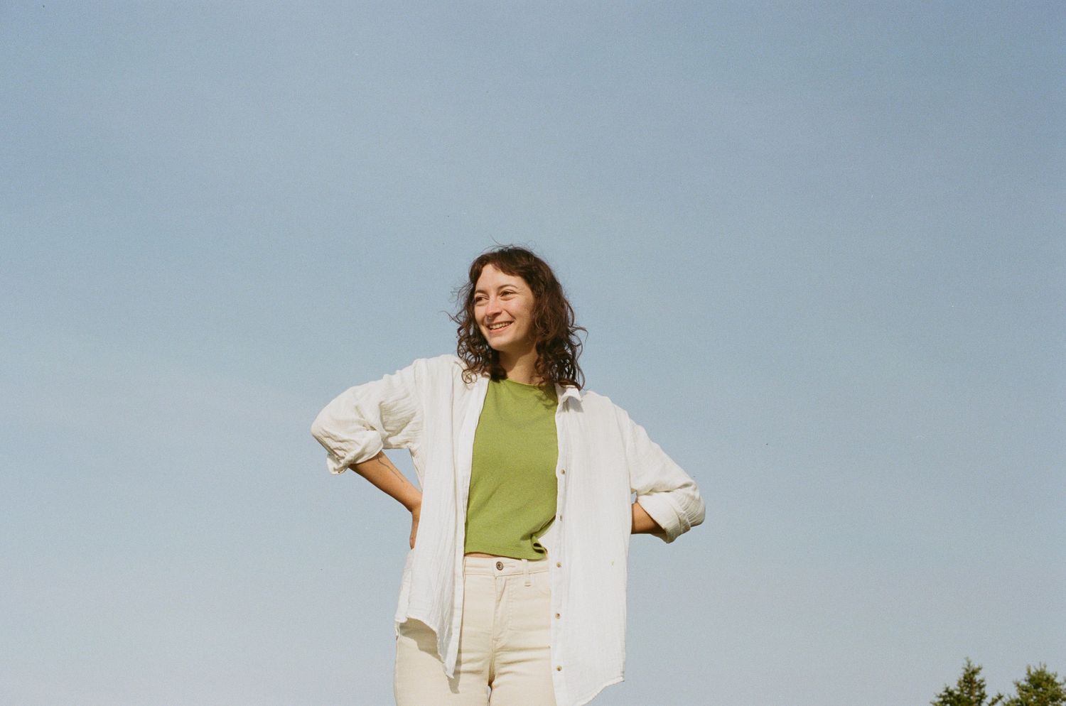 Vancouver Island Elopement Photographer Heather Nolan smiles serenely as they look off camera. They are wearing a loose linen shirt