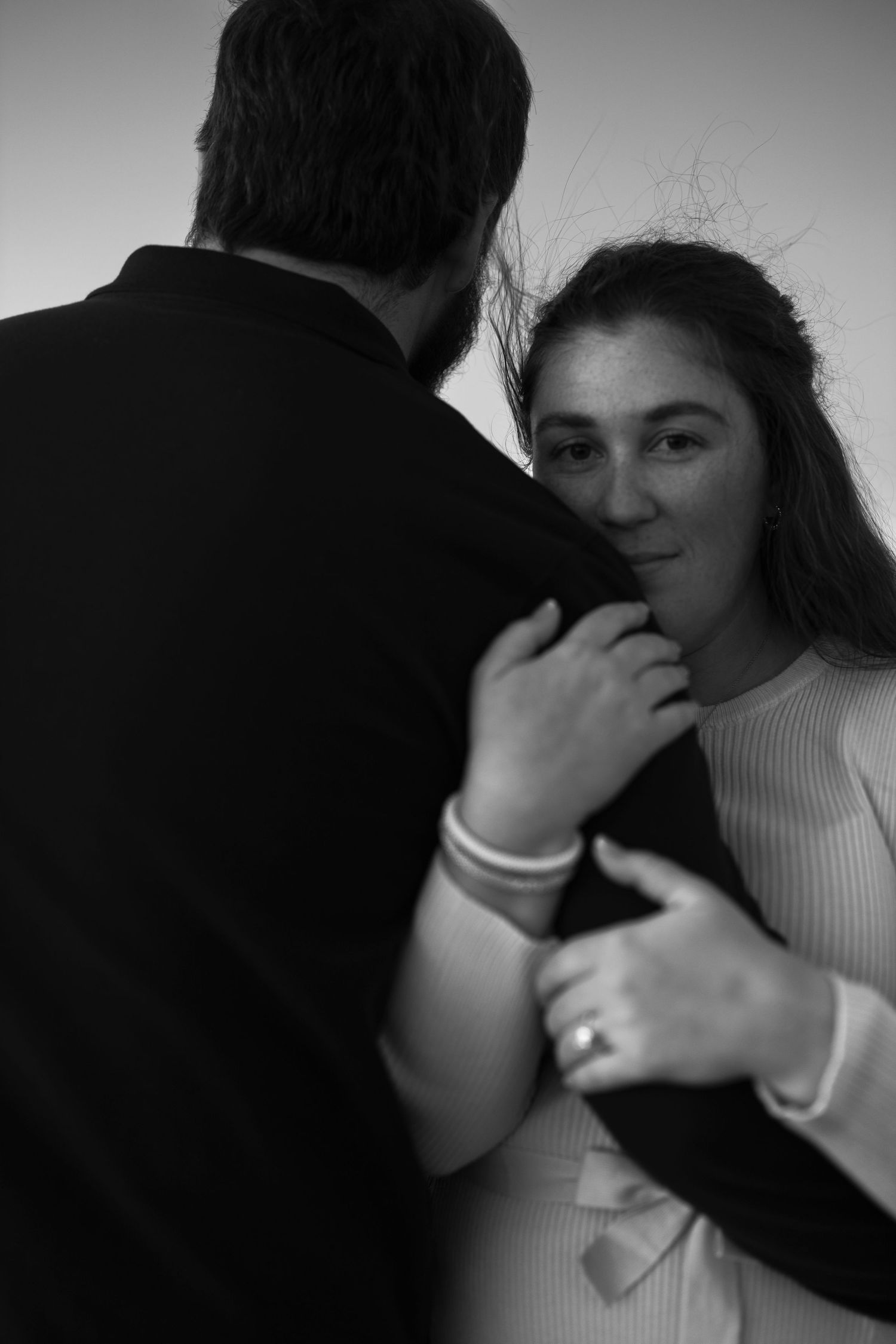 A black and white photo sequence shows two people in an intimate embrace with one wearing a white sweater.