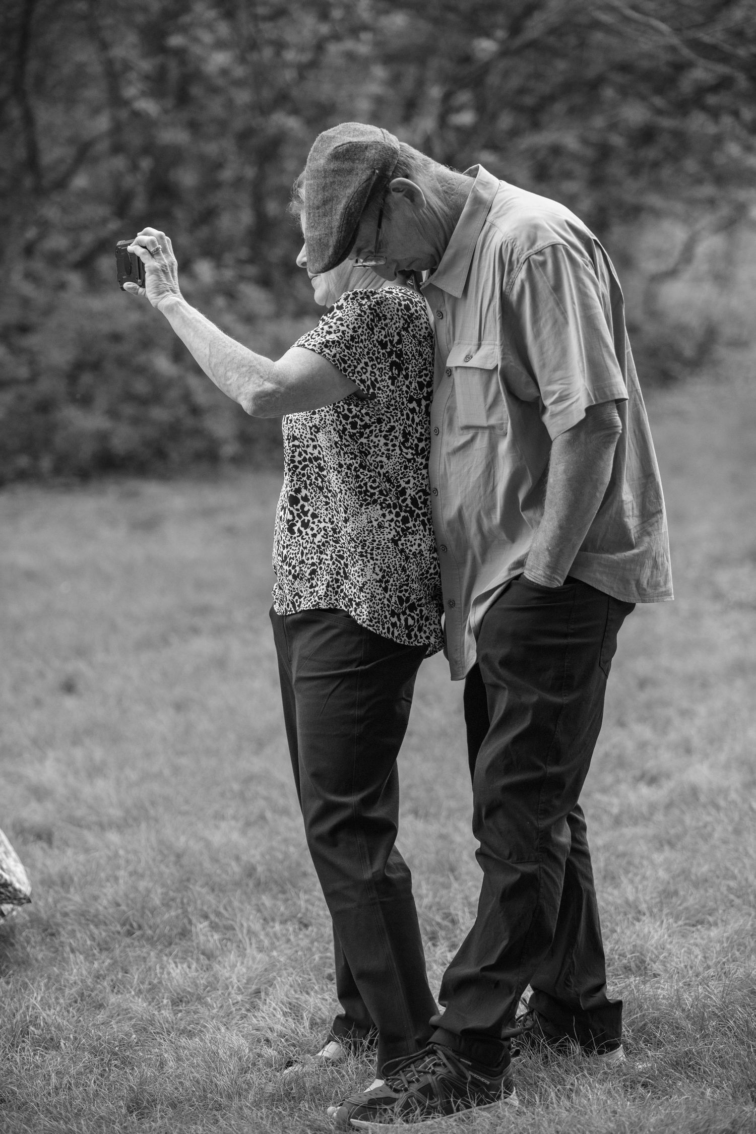 Black and white image of parents enjoying their son's wedding ceremony.