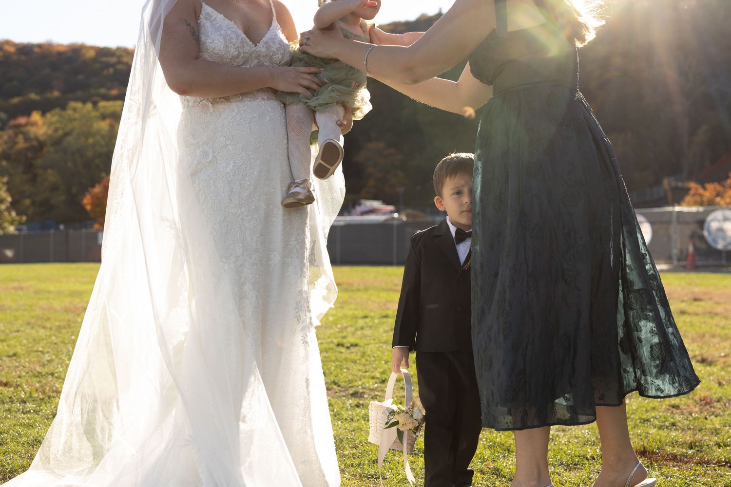 Realistic family portrait during wedding. Direct sunlight. Ring bearer stares into camera. Artistic Coverage. Bear Mountain Inn NY