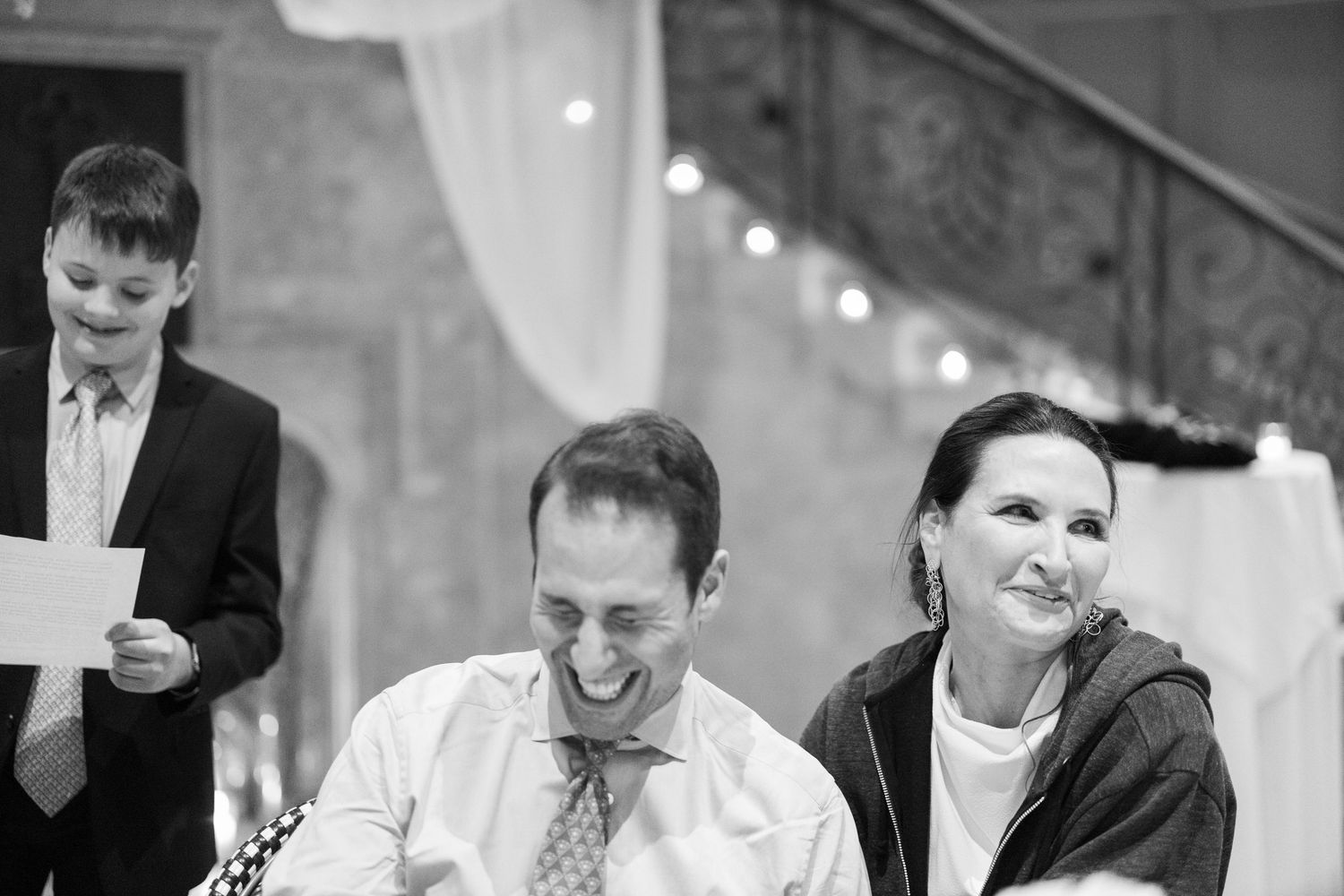 Collage of black and white photos showing people laughing and smiling during a joyful celebration event.