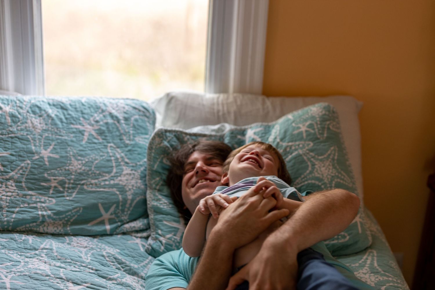 at home Family Session in Branford Connecticut. Son and Father Mid Laughter. Natural Light