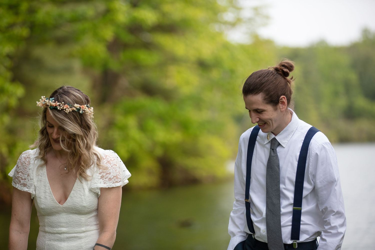 A romantic wedding couple poses outdoors in a garden setting surrounded by lush greenery.