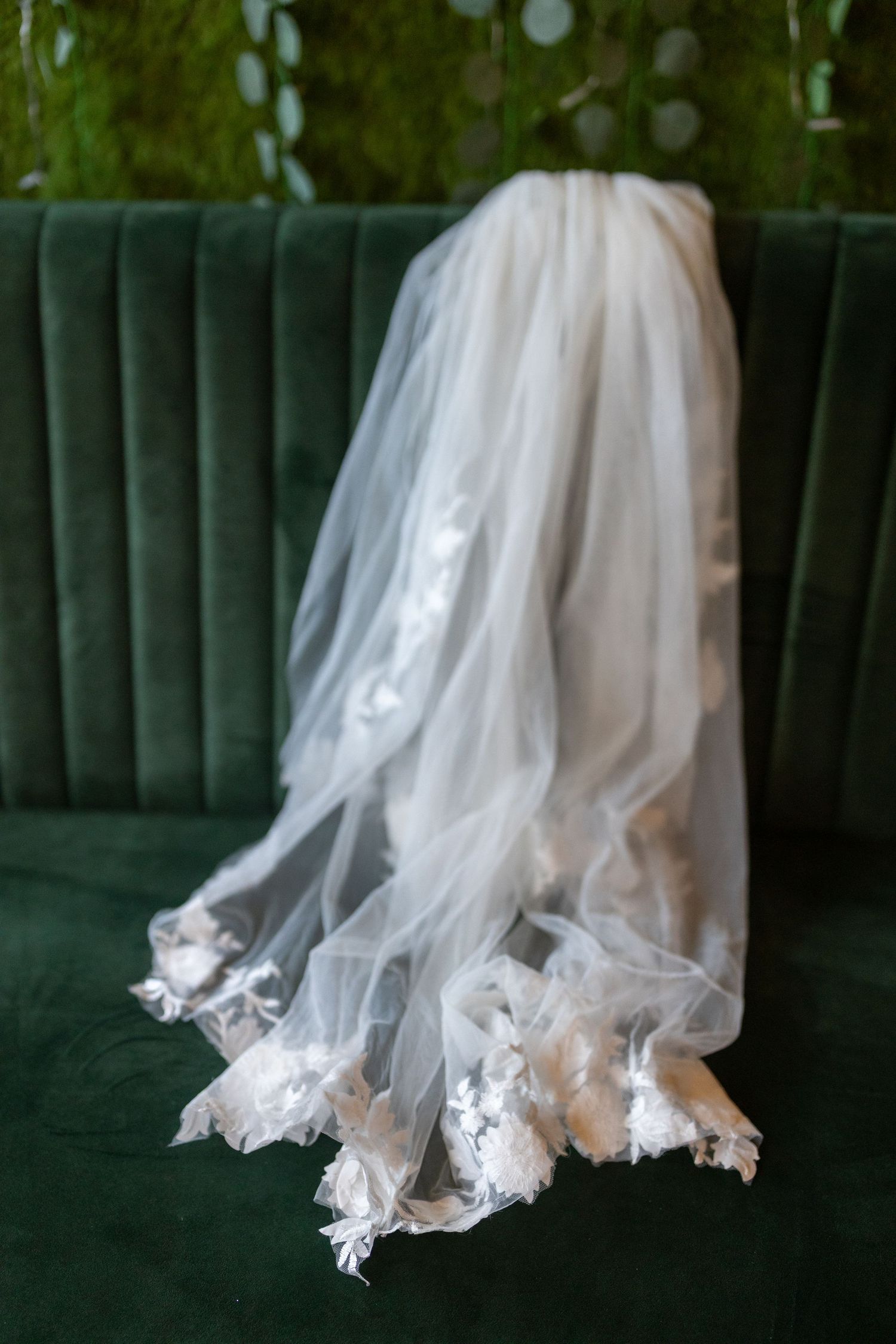 Portrait of bride's veil sitting on vintage green couch.