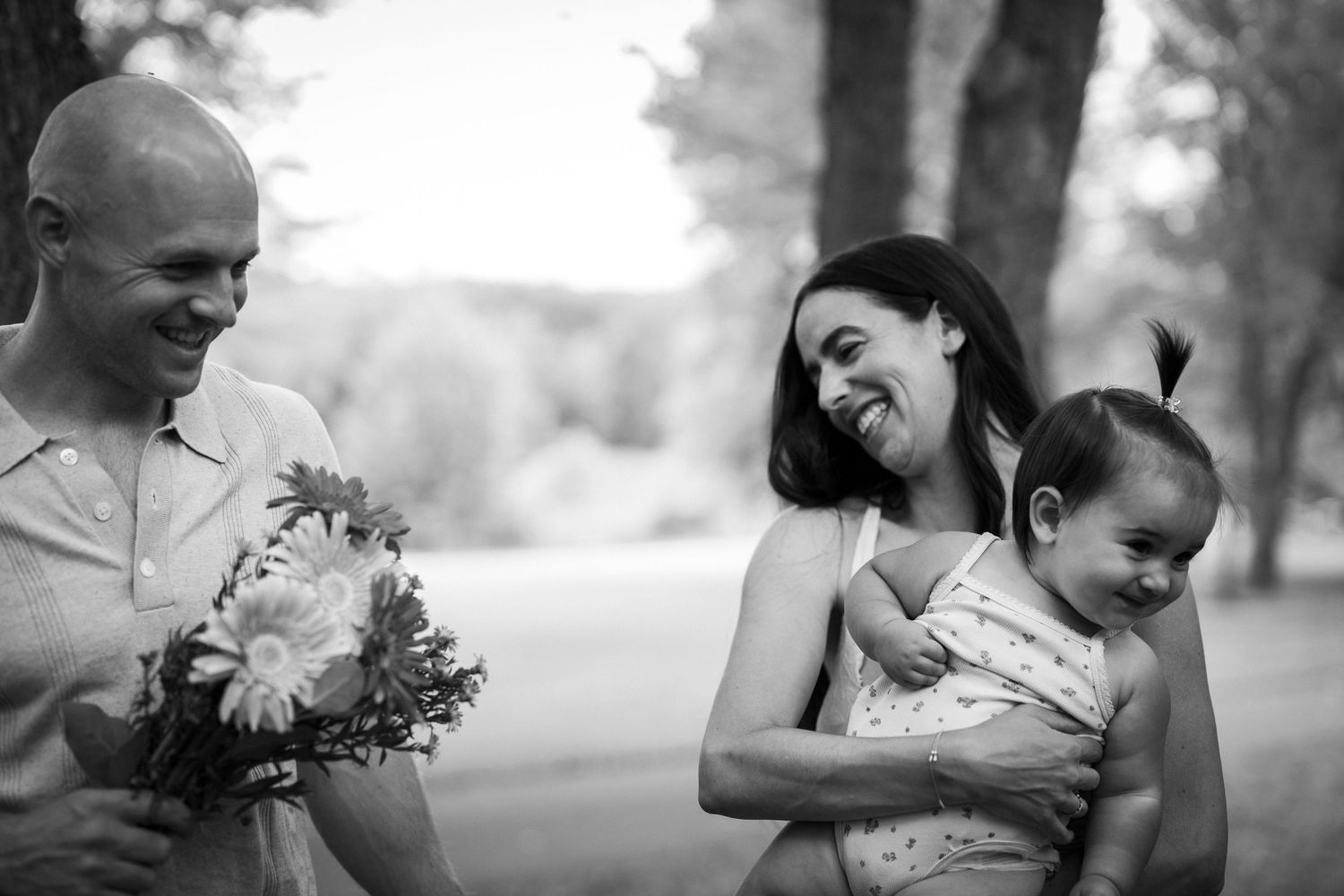 A series of tender black and white photographs showing loving family moments in an outdoor setting.