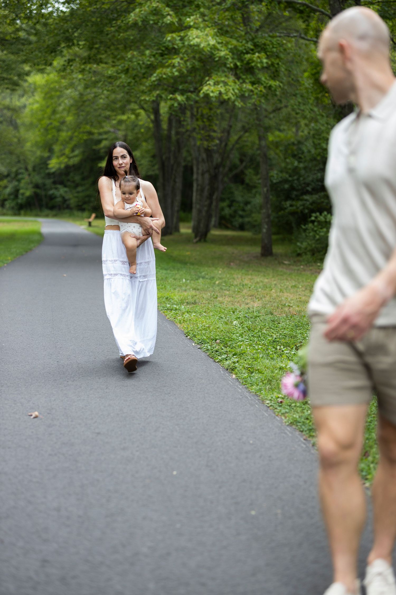Mother holds baby as she towards her husband. Twin Books Park. Trumbull Connecticut.