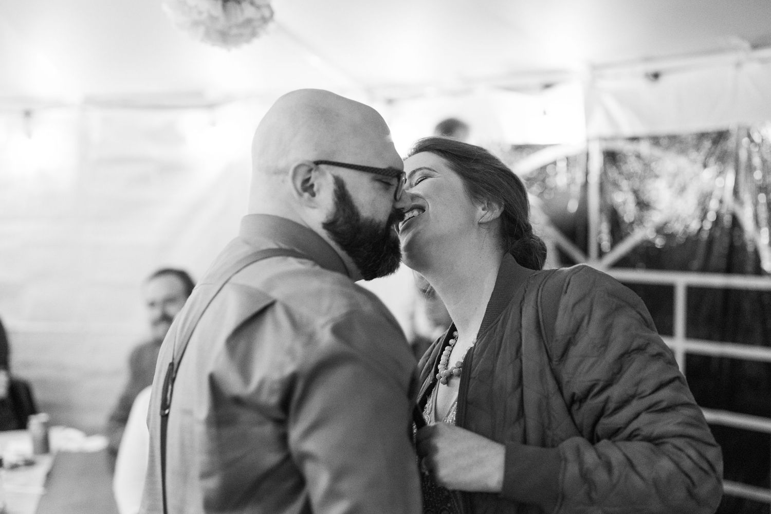 A black and white photo strip showing four sequential romantic moments between a couple sharing kisses and embraces.