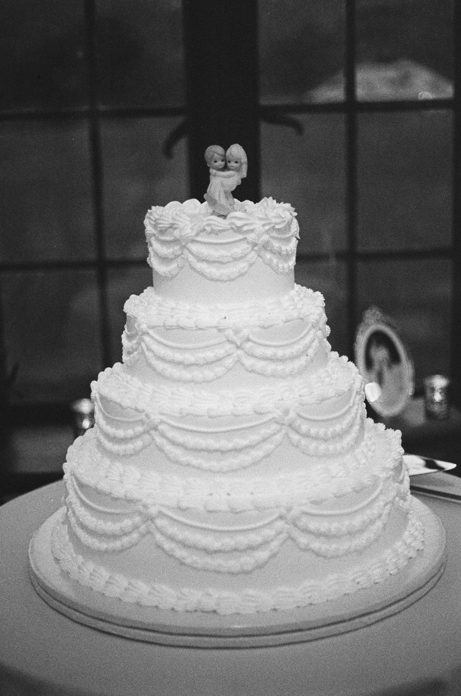 A black and white film showing a vintage cake topper at wedding reception in NY. Bear Mountain Inn.